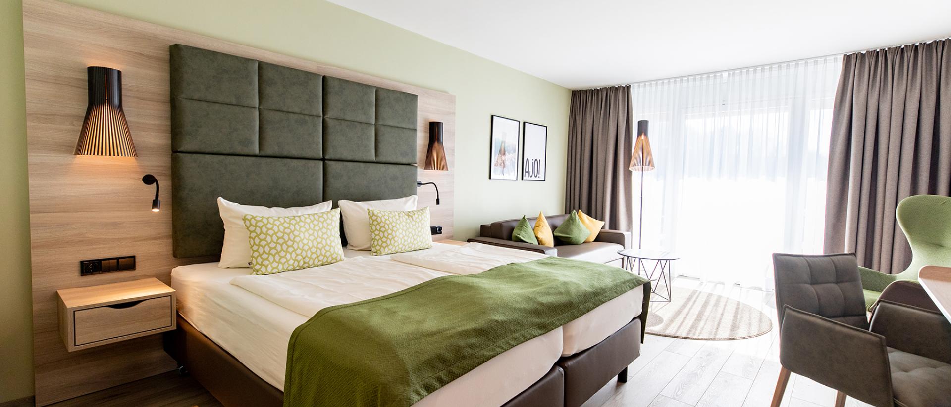 Modernes Doppelzimmer im Pfalzblick Wald Spa Resort mit grünem Dekor und natürlichem Licht