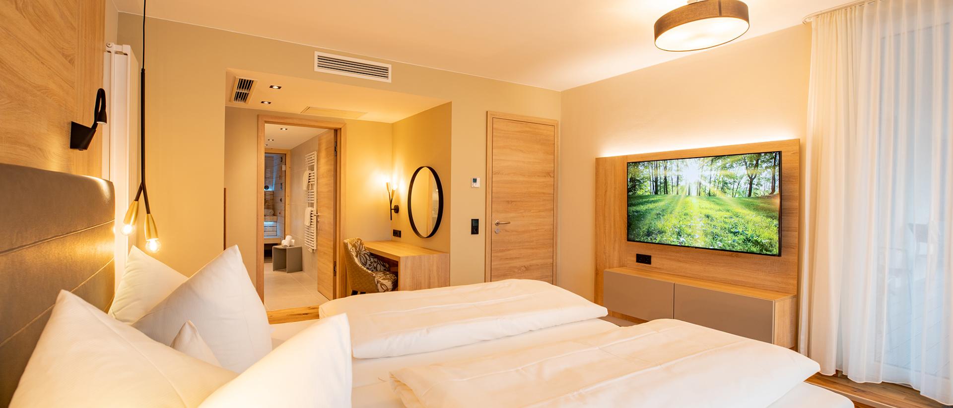Modernes Schlafzimmer im Pfalzblick Wald Spa Resort mit Holzdesign und TV