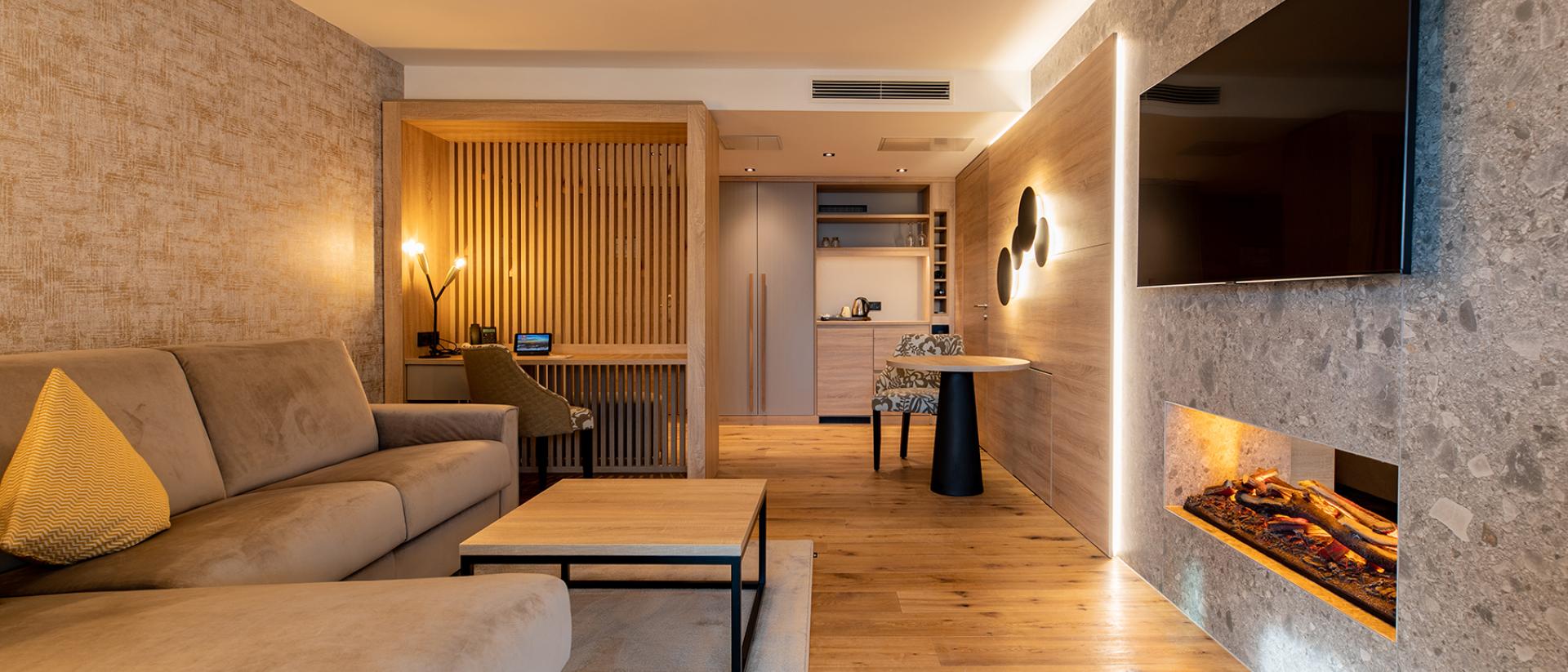 Moderner Wohnbereich im Pfalzblick Wald Spa Resort mit Kamin und Fernseher
