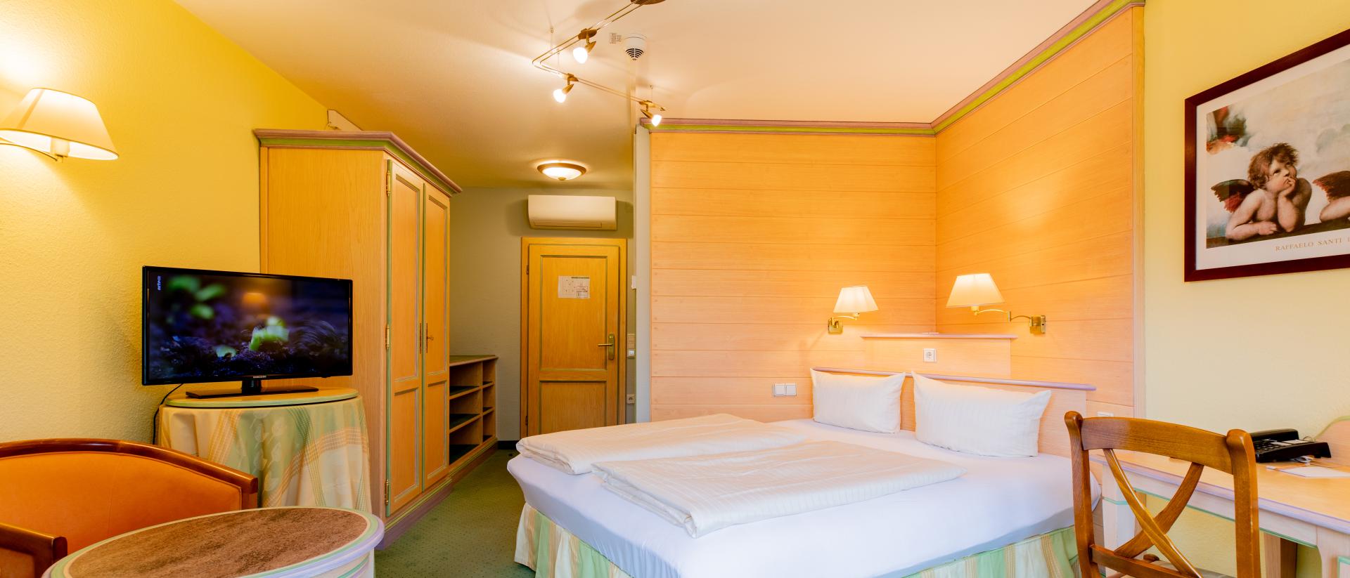 Gemütliches Zimmer im Pfalzblick Wald Spa Resort mit Doppelbett und TV