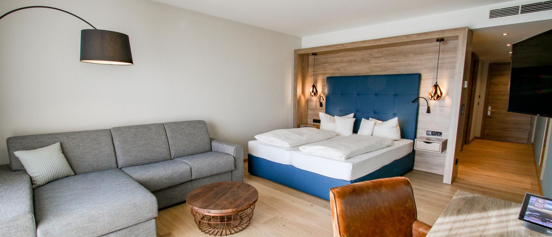 Modernes Hotelzimmer im Pfalzblick Wald Spa Resort mit Bett und Sofa