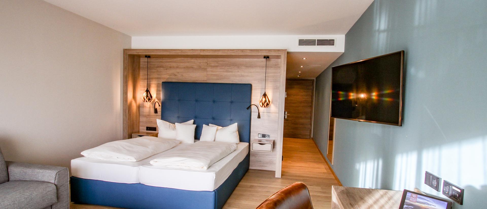 Modernes Hotelzimmer im Pfalzblick Wald Spa Resort mit Doppelbett und Schreibtisch