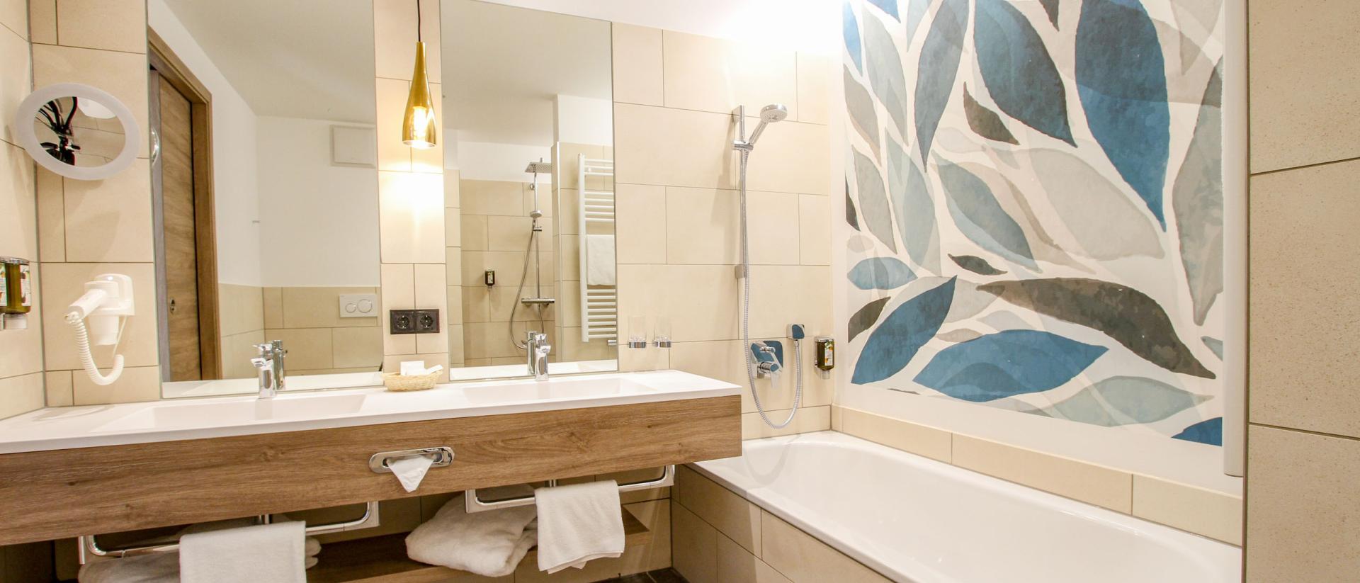 Modernes Badezimmer im Pfalzblick Wald Spa Resort mit Badewanne und Waschtisch