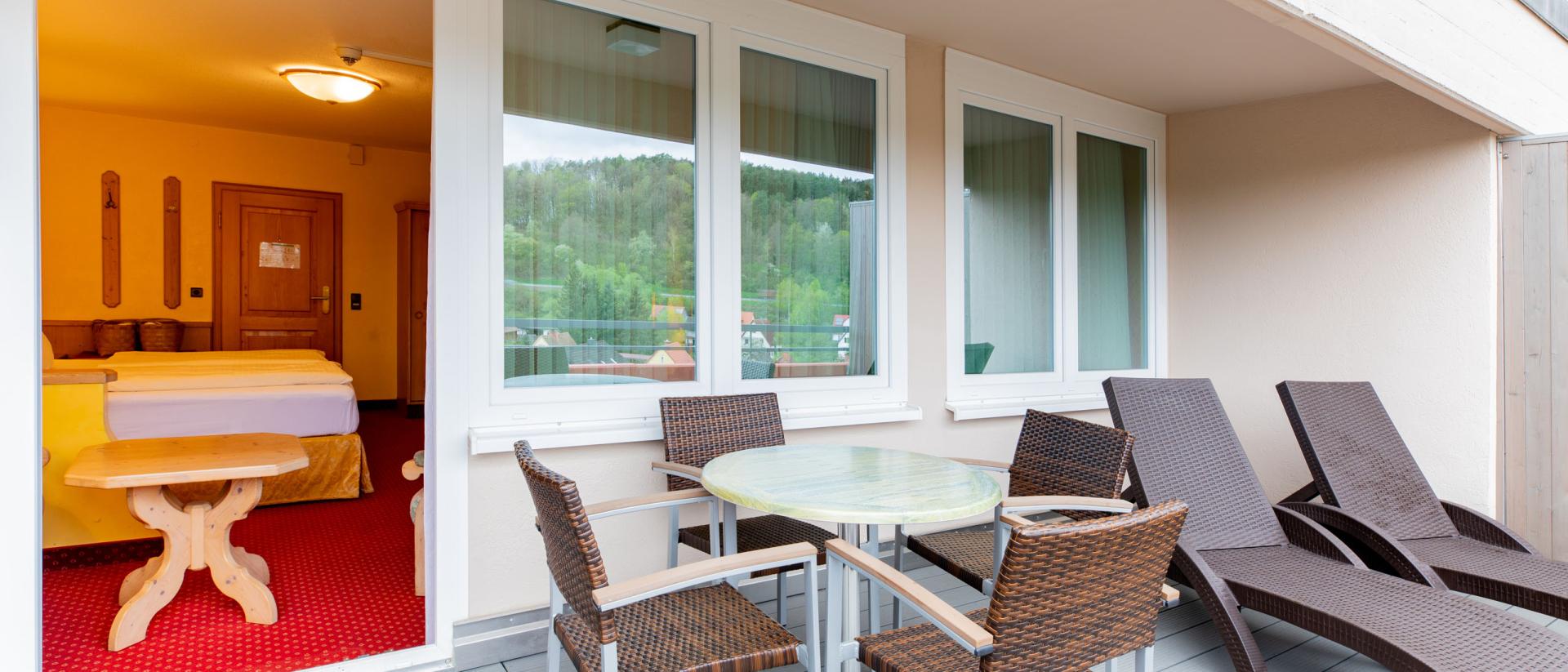 Balkon mit Sitzbereich im Pfalzblick Wald Spa Resort mit Blick auf den Wald