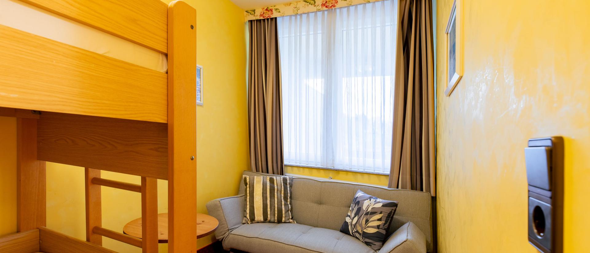 Gemütlicher Raum mit Etagenbett und Sofa im Pfalzblick Wald Spa Resort