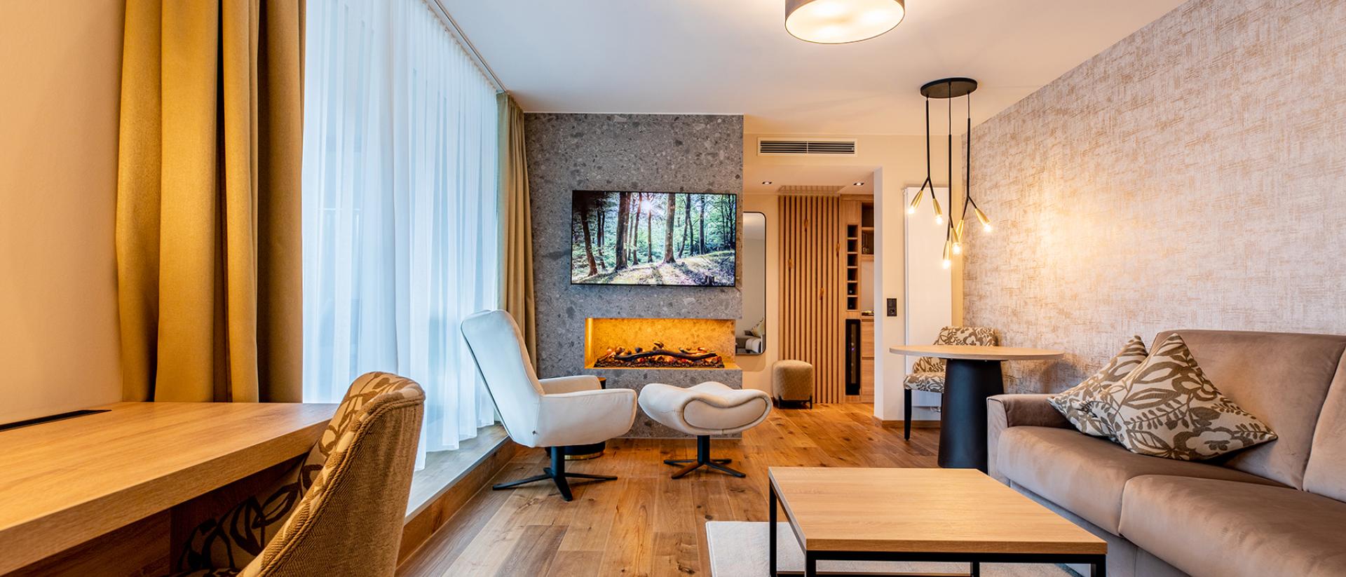 Modernes Wohnzimmer im Pfalzblick Wald Spa Resort mit Kamin und gemütlicher Einrichtung