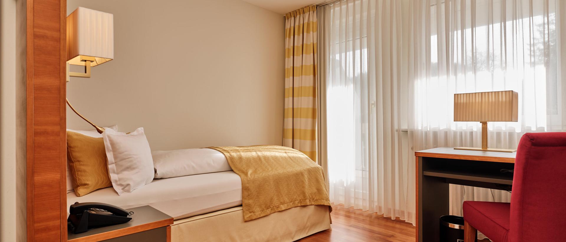 Modernes Einzelzimmer im Hotel Reppert mit Holzfußboden und warmem Licht