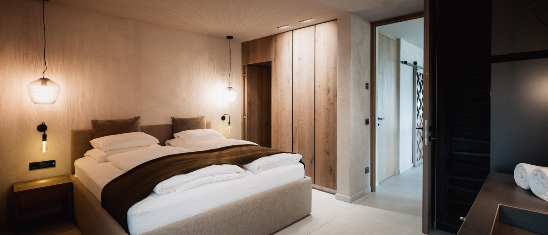 Camera da letto del Chalet Purmontes con design moderno e dettagli in legno caldi