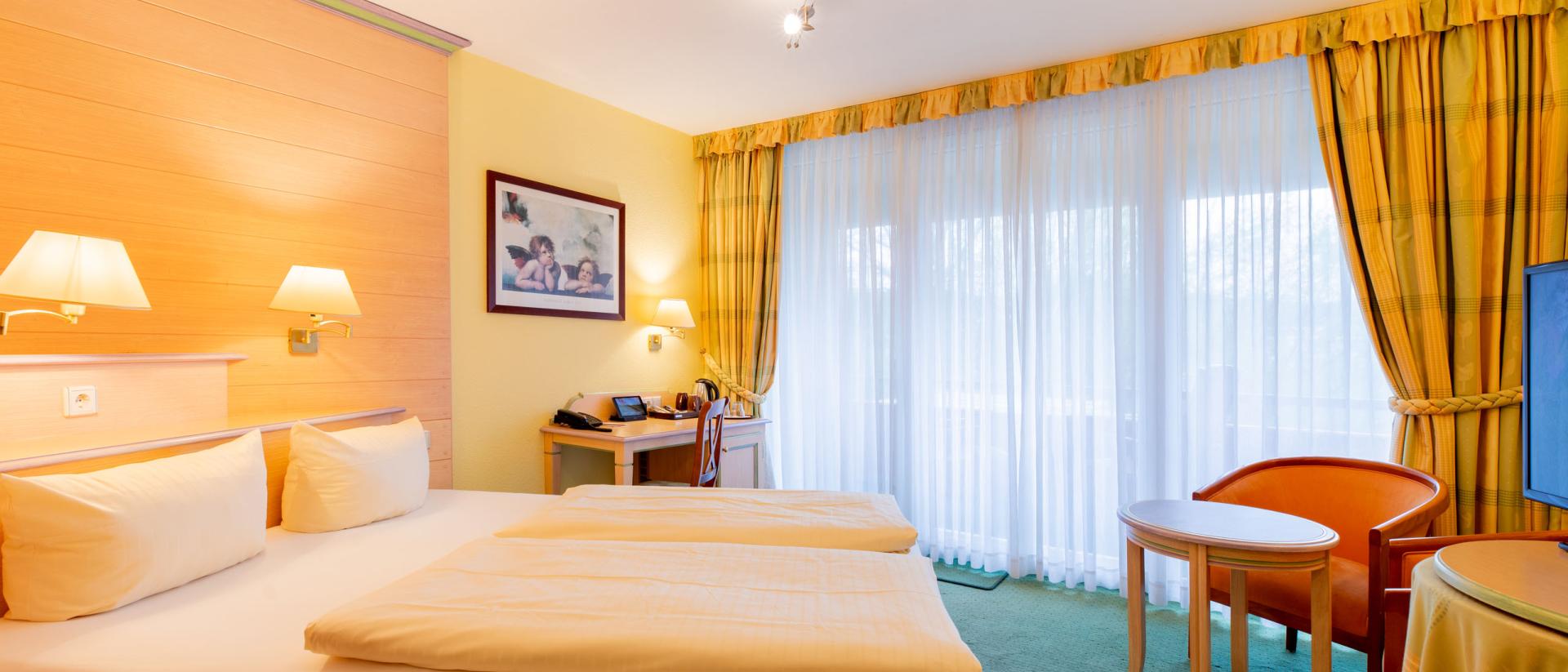 Hell eingerichtetes Doppelzimmer im Pfalzblick Wald Spa Resort mit großem Fenster