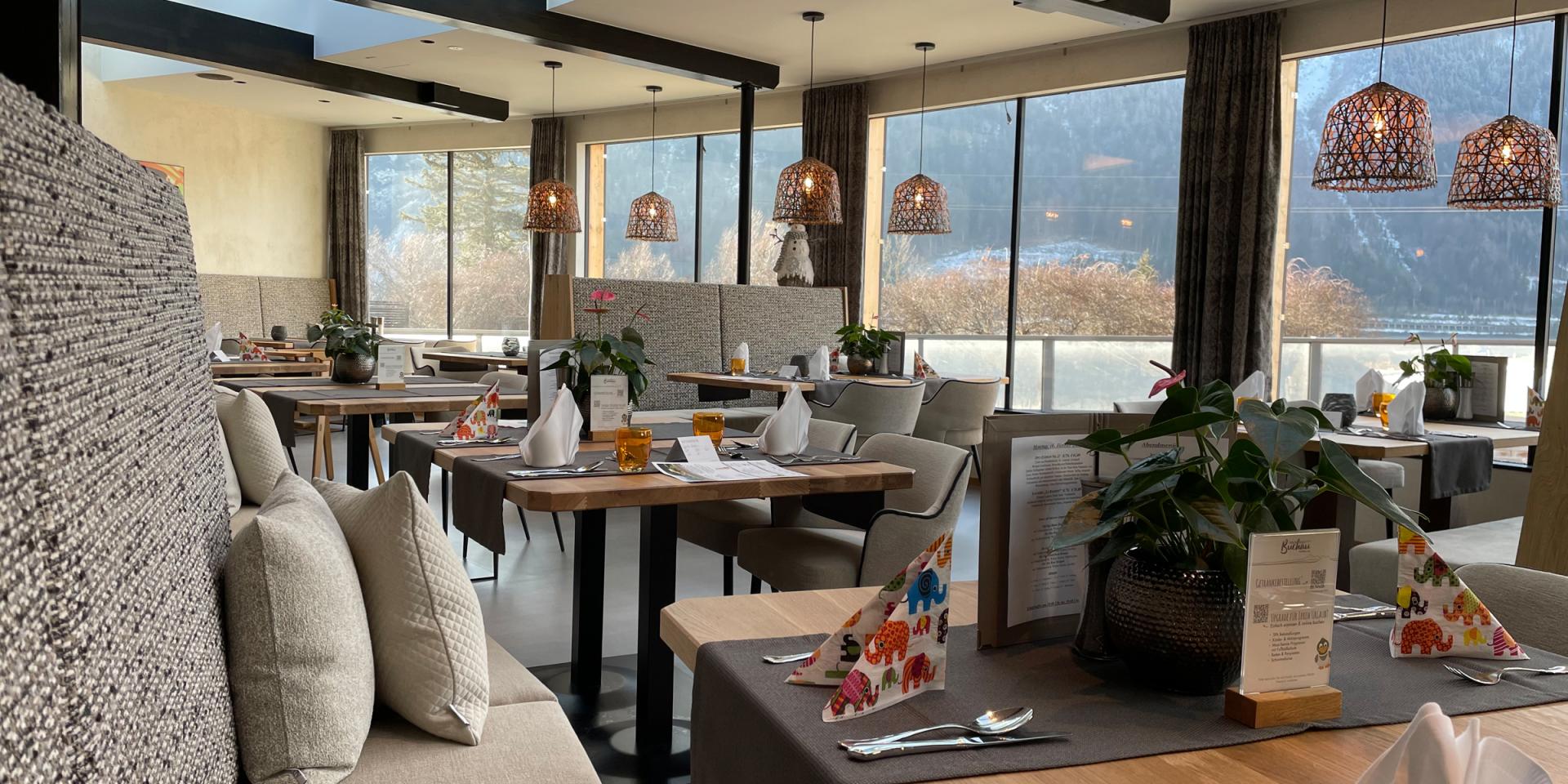 Modern dining area at Familienresort Buchau with seating and large windows