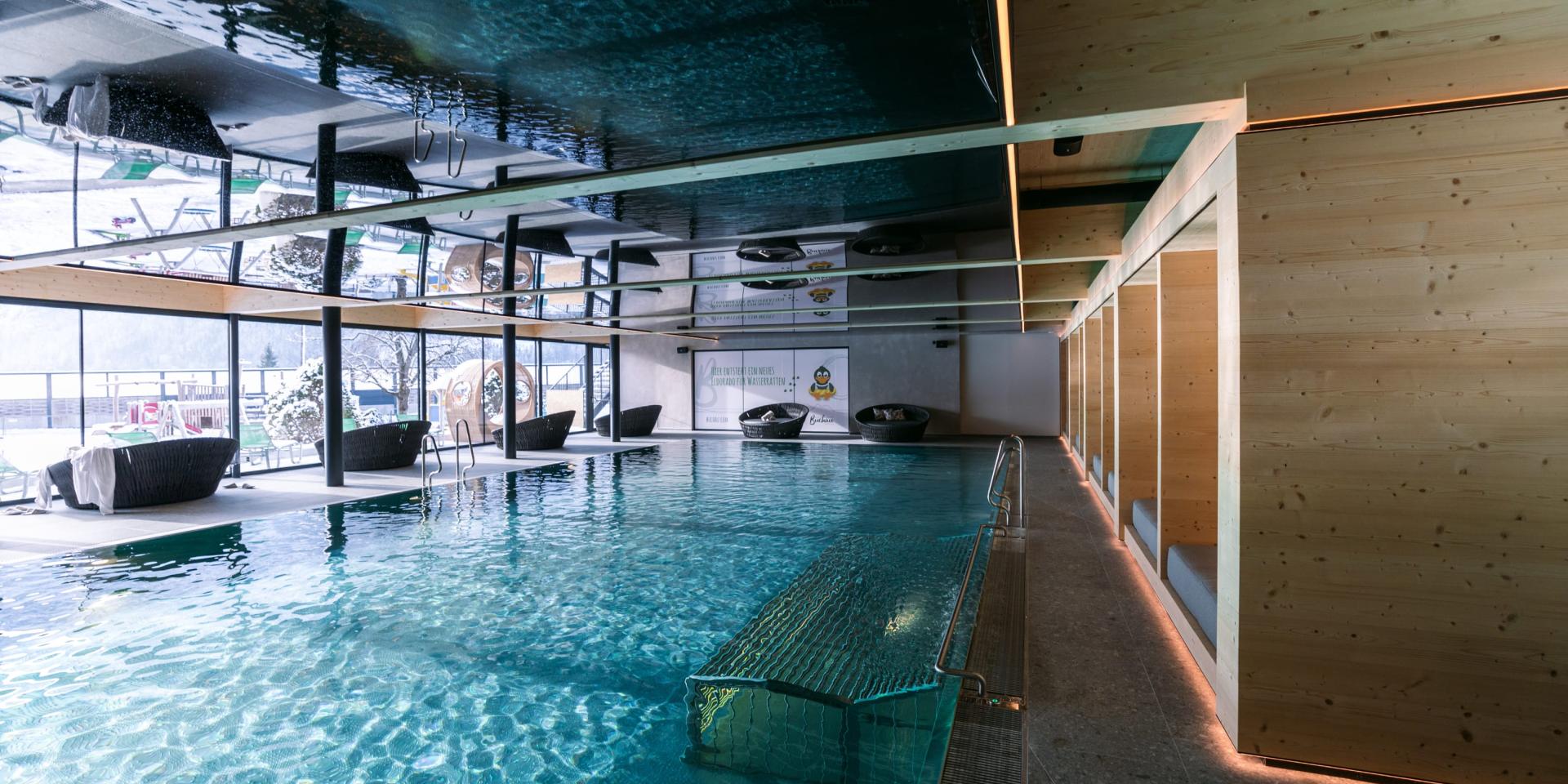 Innenpoolbereich im Familienresort Buchau mit Blick auf verschneite Landschaft