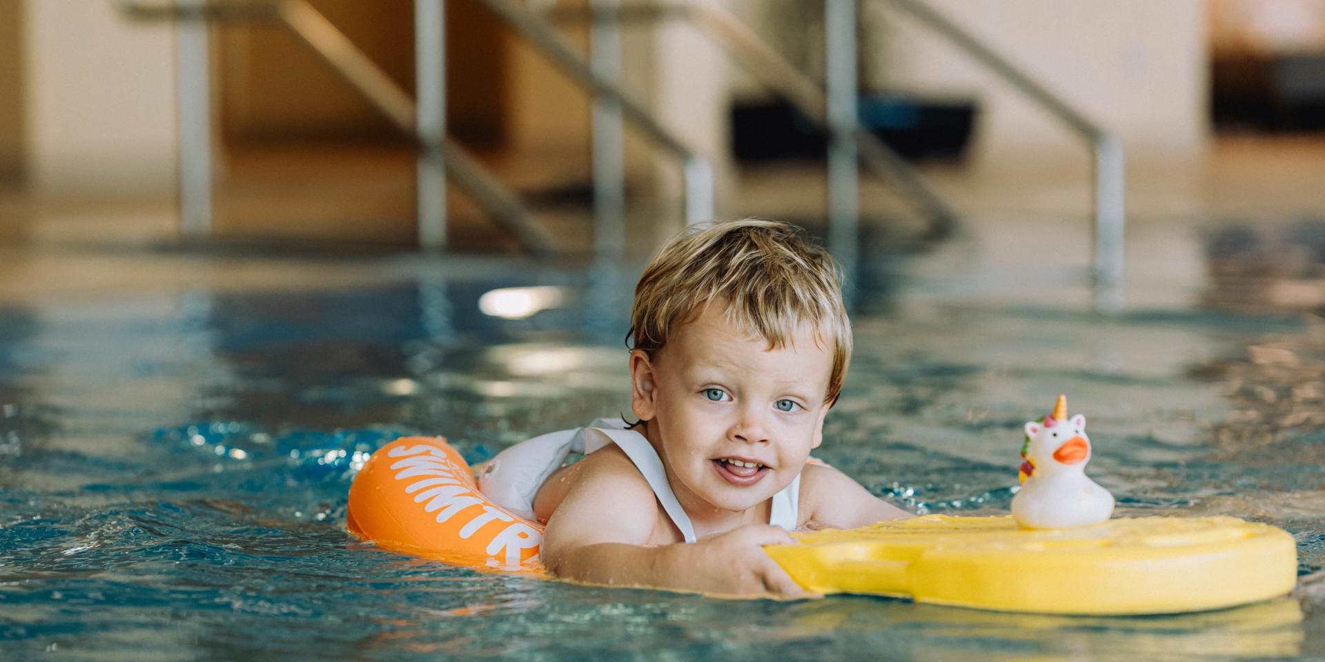 Child swimming with float in pool at Familienresort Buchau