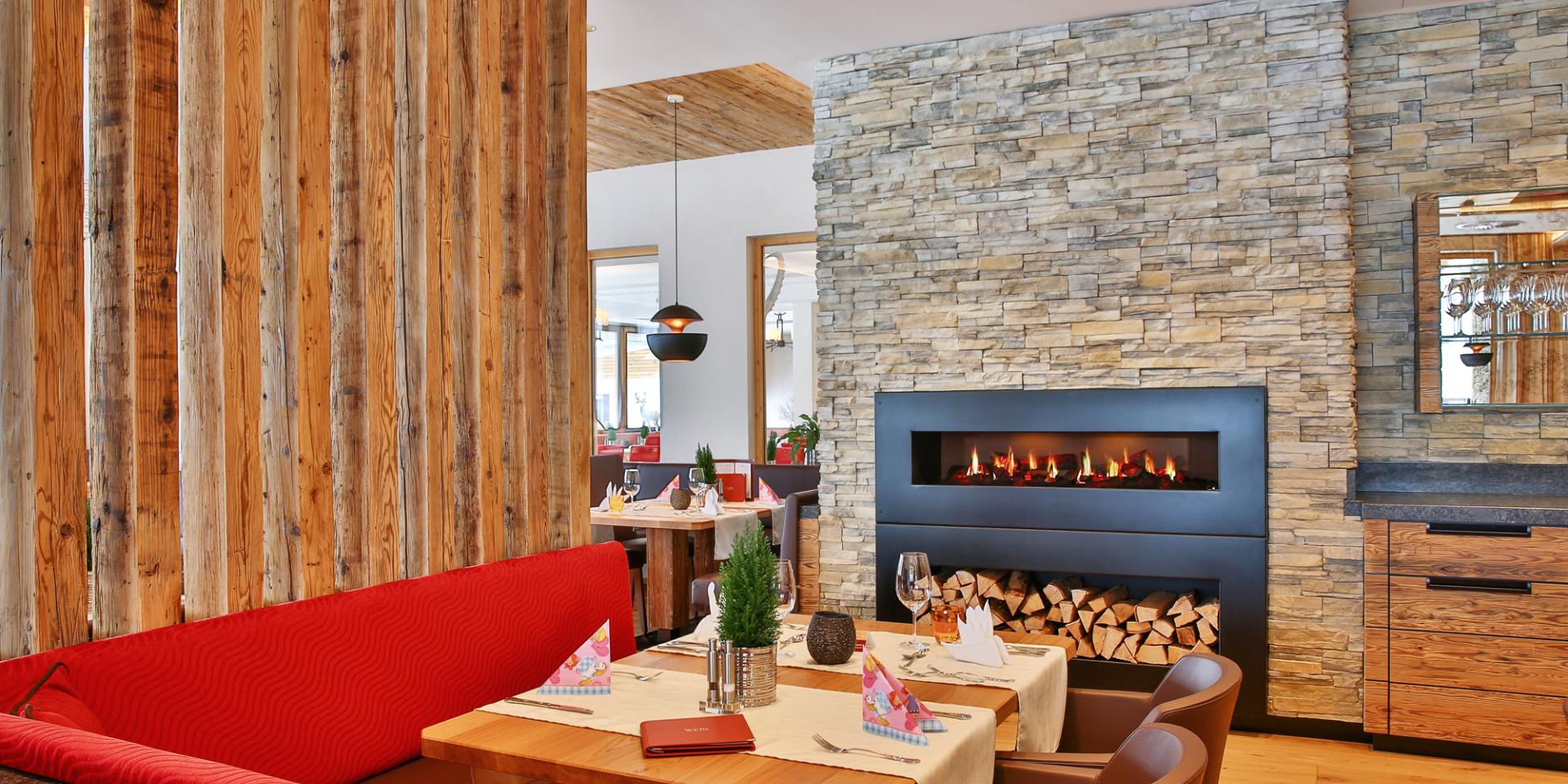Cozy dining area at Familienresort Buchau with fireplace and wooden accents