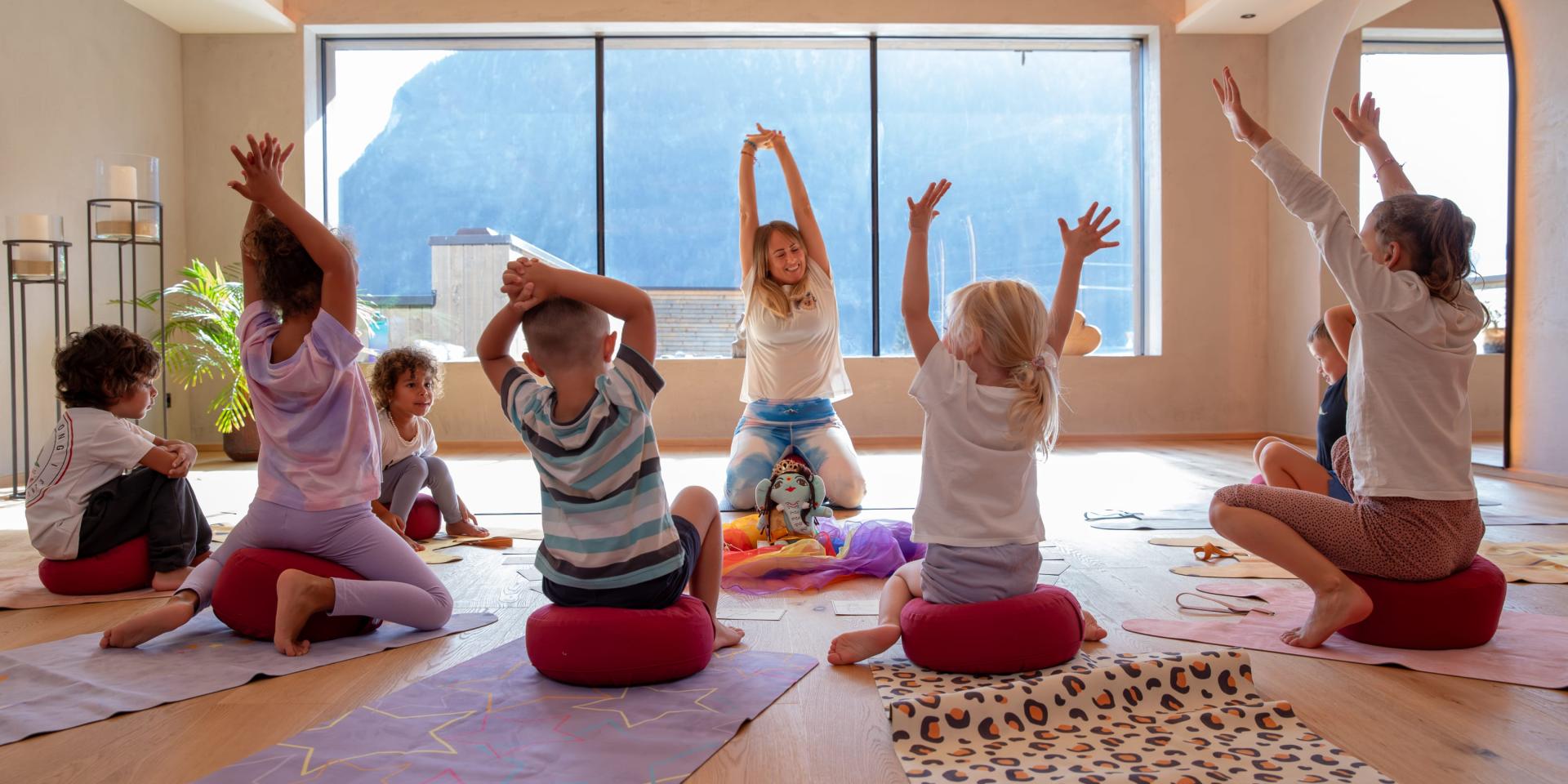 Children practicing yoga at Familienresort Buchau with mountain view