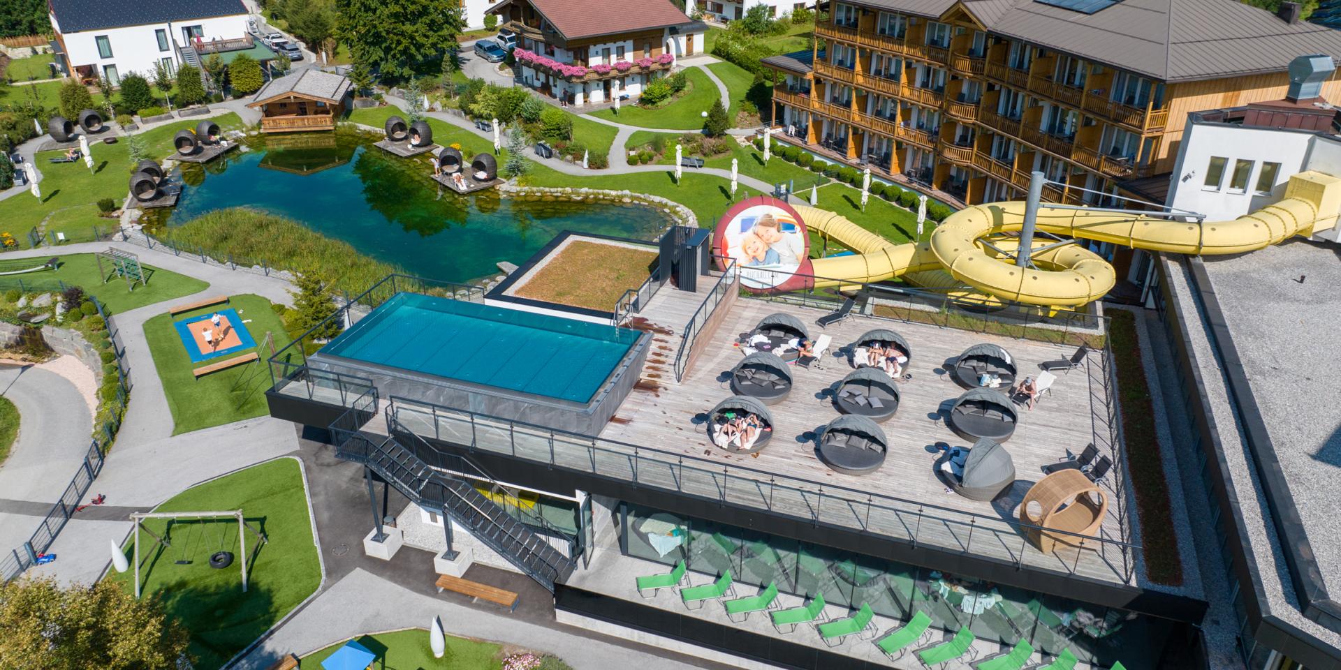 Aerial view of Familienresort Buchau with pool, slide and playground in green surroundings