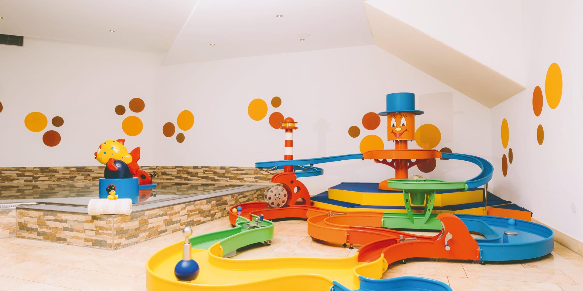 Kinder Wasserspielbereich im Familienresort Buchau mit bunten Rutschen und Figuren