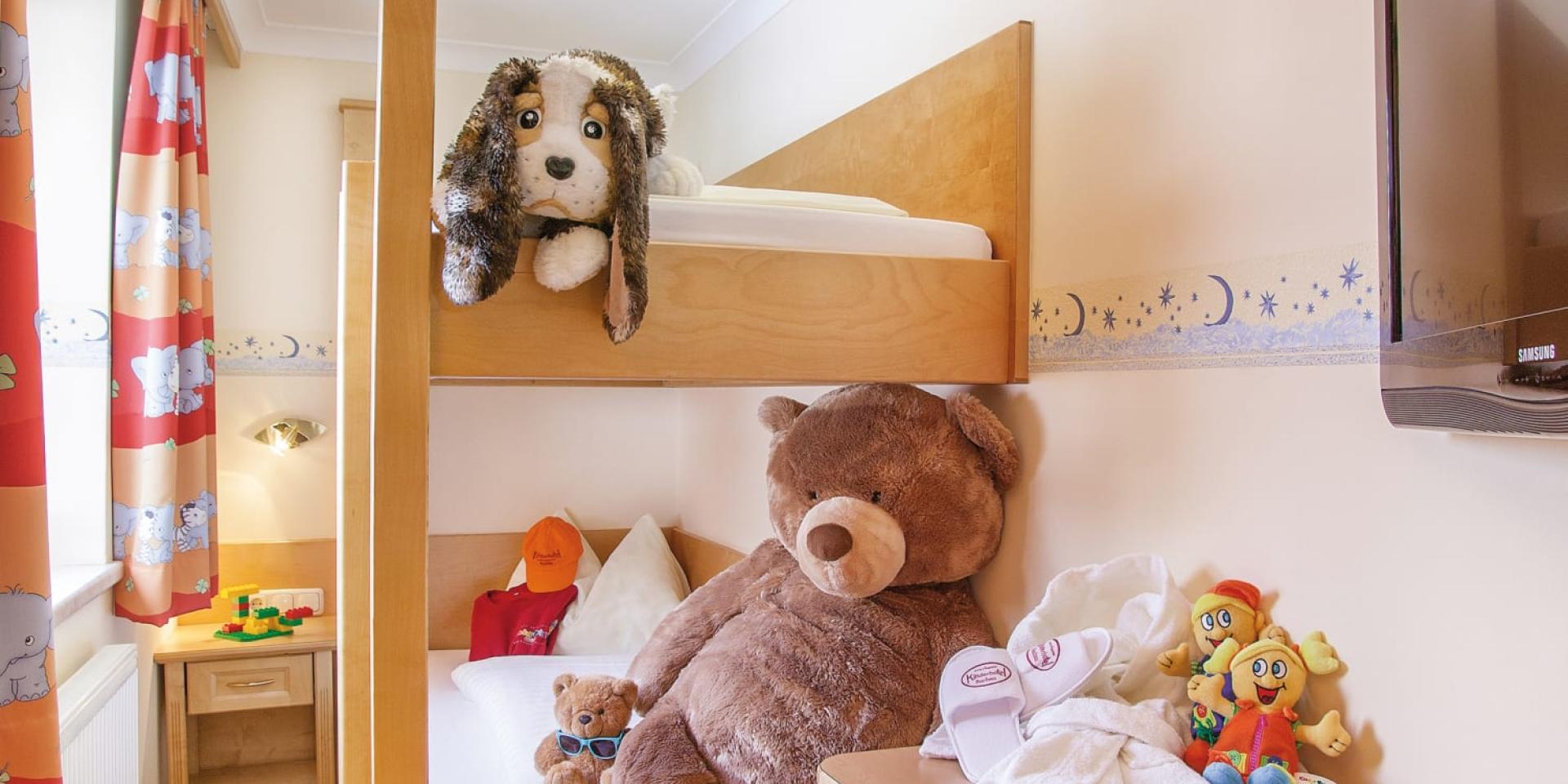 Kids room with bunk bed and stuffed animals at Familienresort Buchau