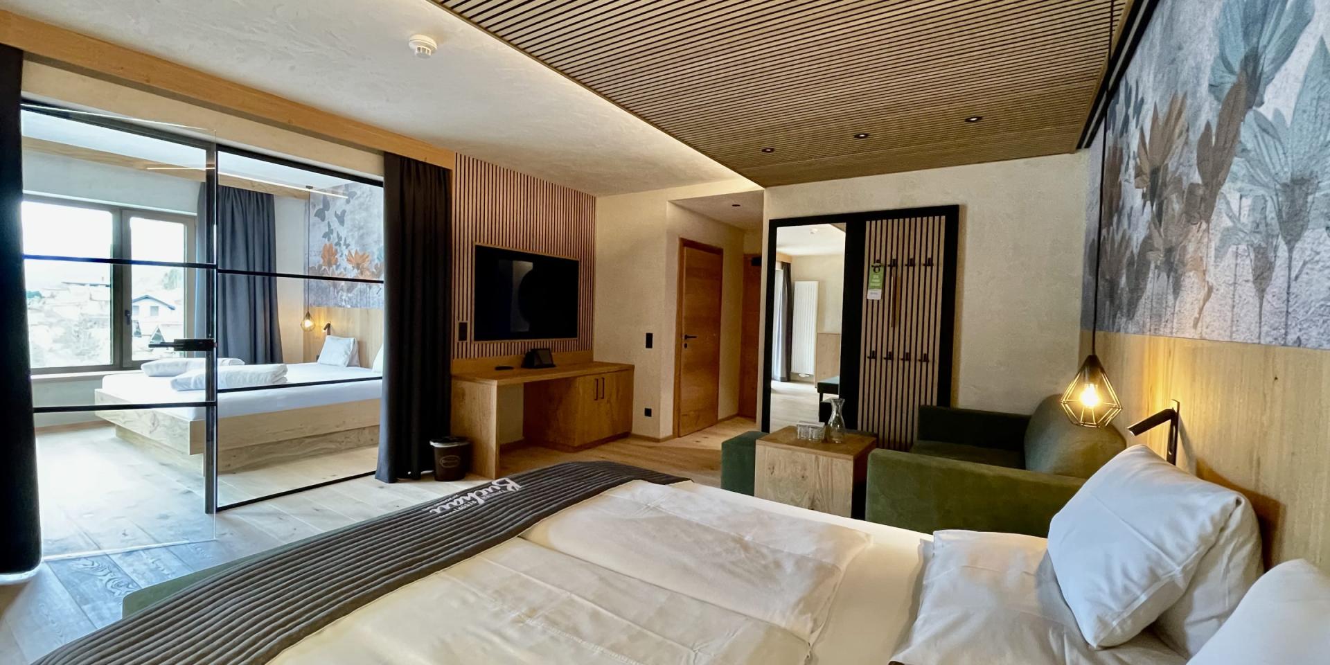 Modern eingerichtetes Zimmer im Familienresort Buchau mit Bett und Sitzbereich