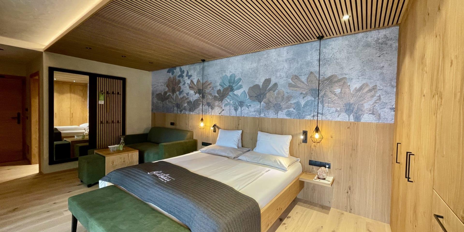 Modernes Schlafzimmer im Familienresort Buchau mit Holzeinrichtung und floralem Wandbild
