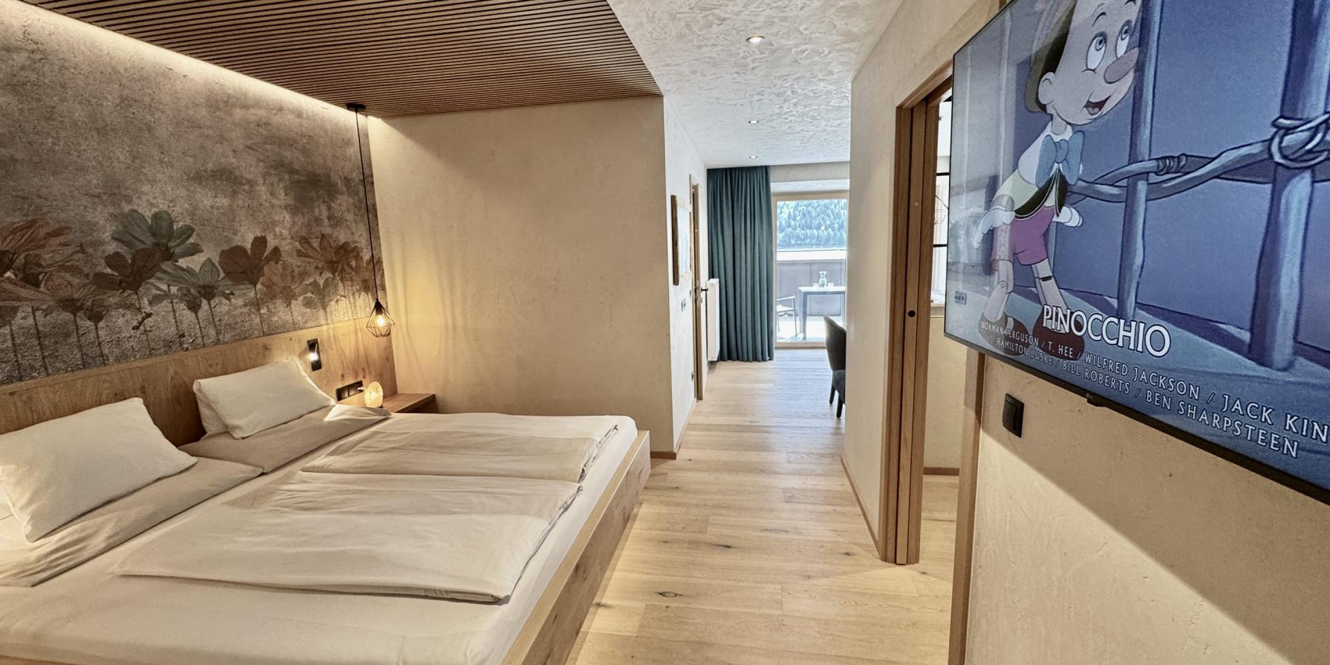 Modernes Schlafzimmer im Familienresort Buchau mit Fernseher und Holzboden