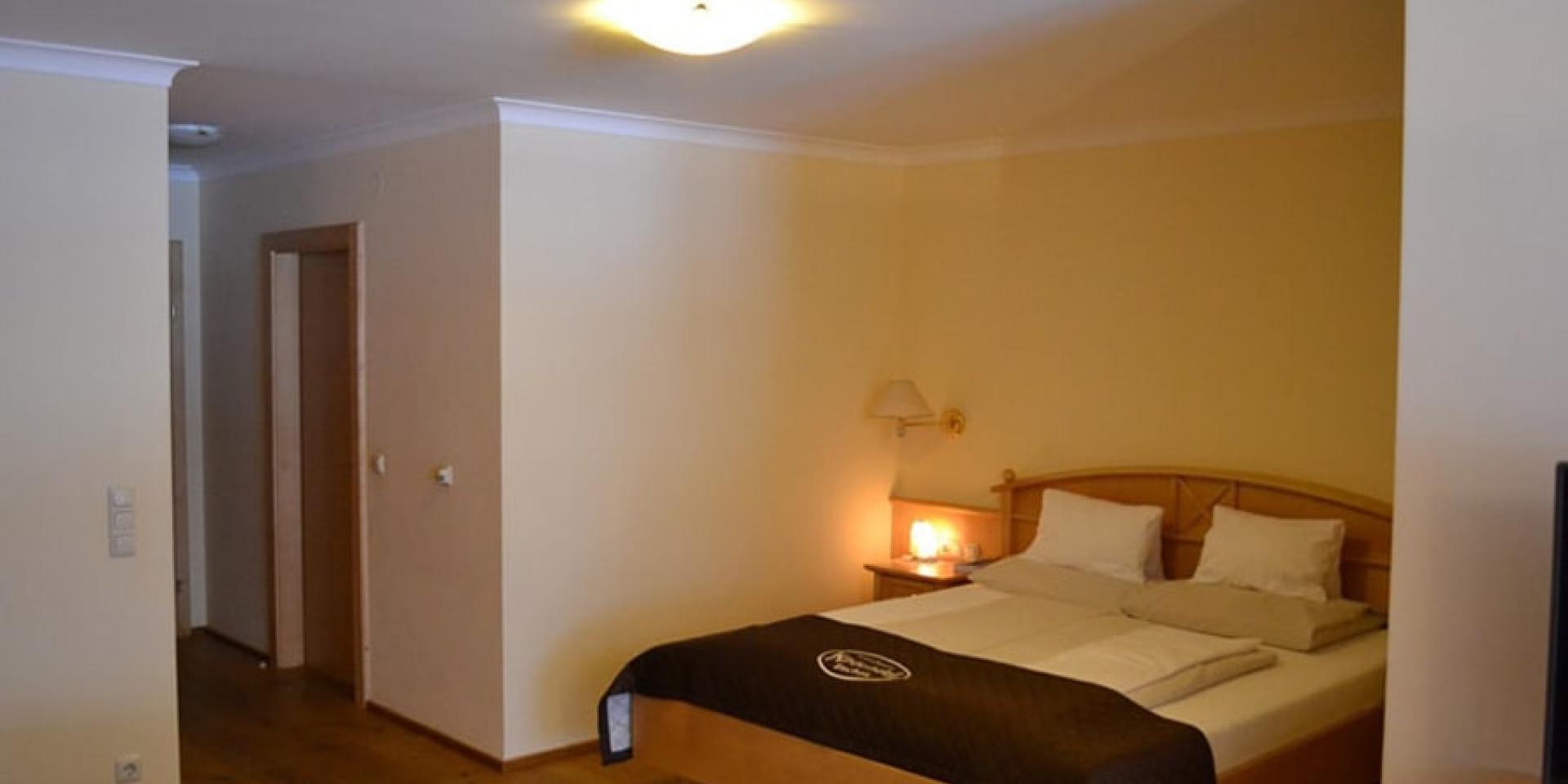 Gemütliches Schlafzimmer im Familienresort Buchau mit Doppelbett und Holzmöbeln