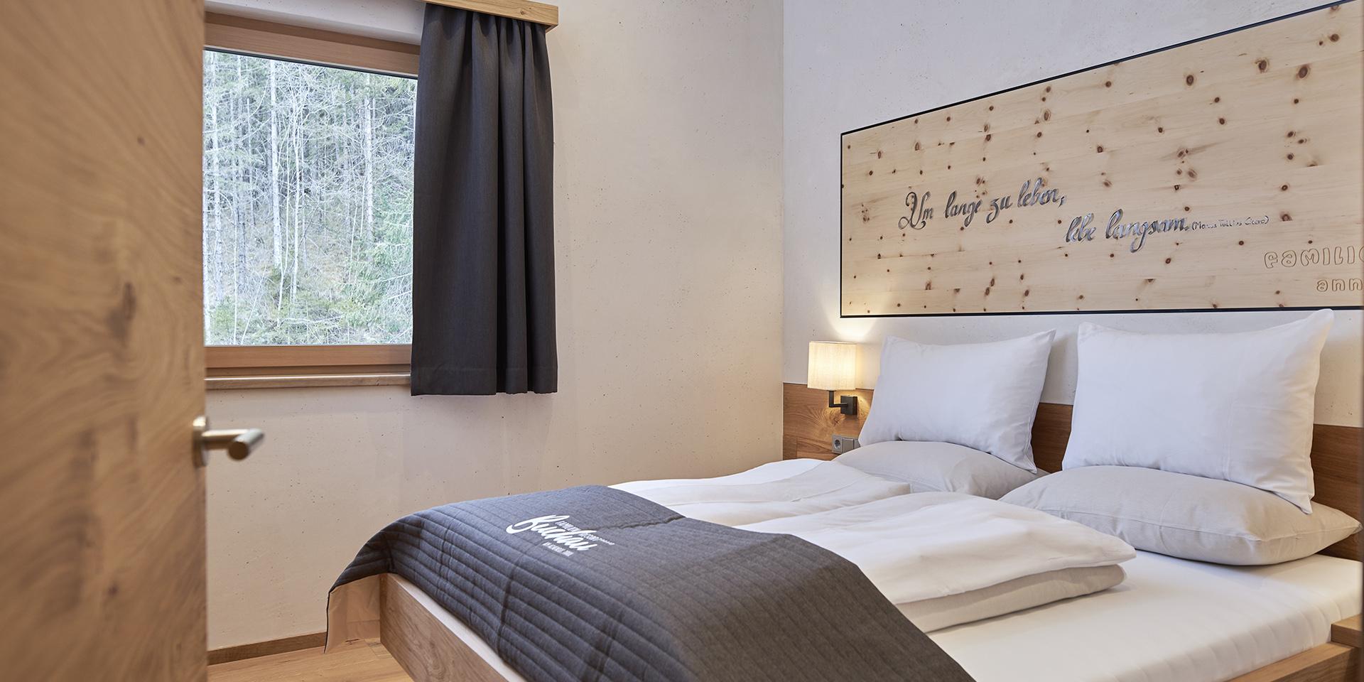 Gemütliches Schlafzimmer im Familienresort Buchau mit Fenster und Holzdetails