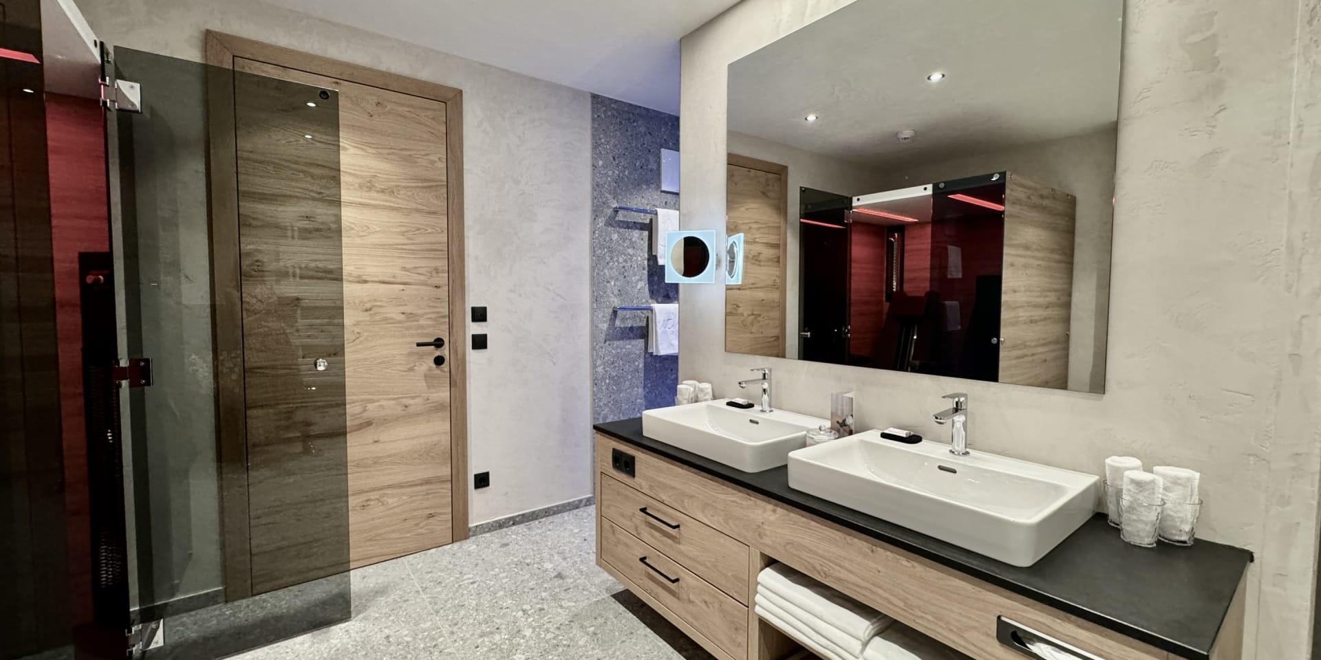 Modern bathroom at Familienresort Buchau with double sinks and wooden cabinets
