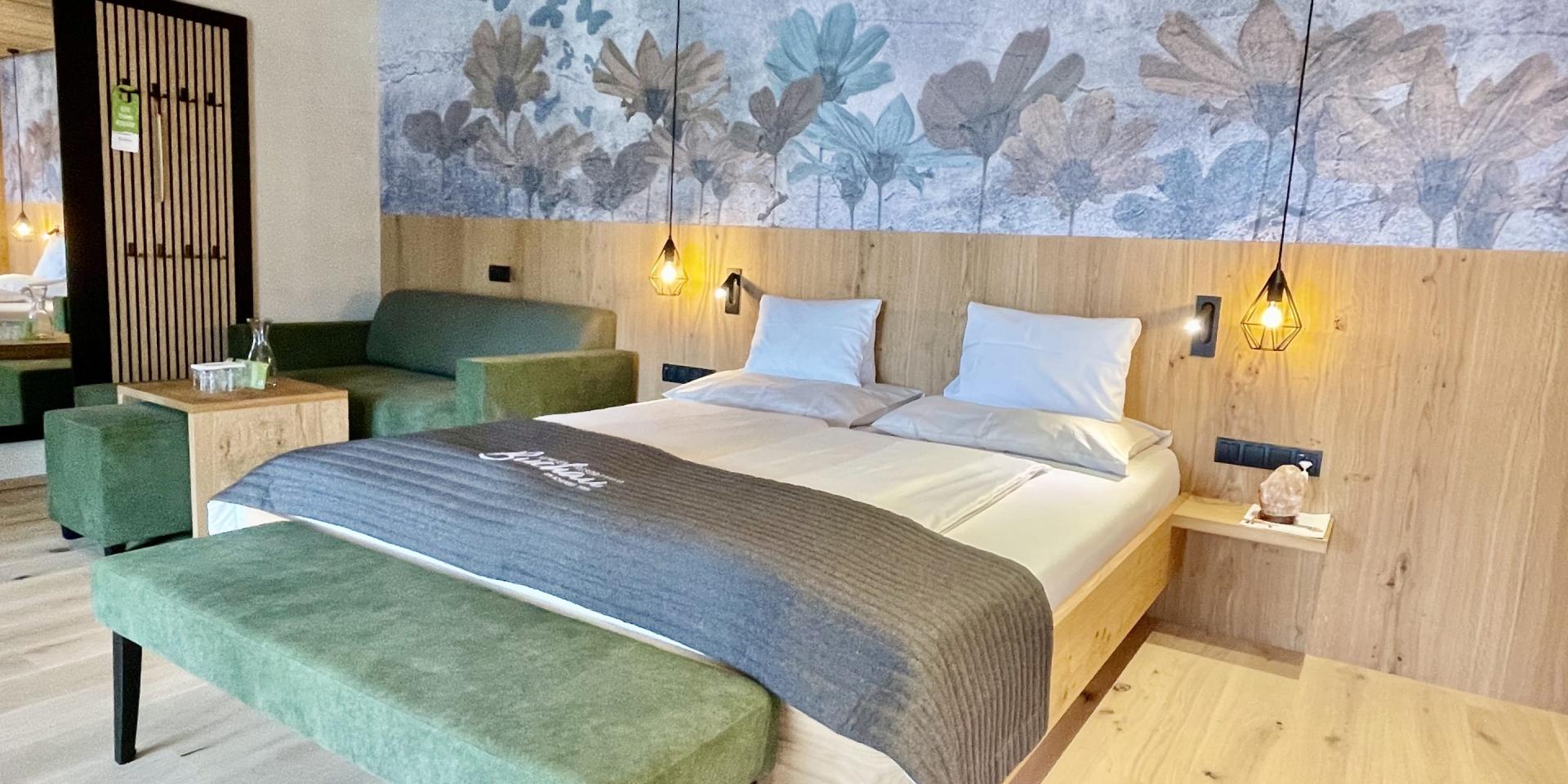 Modernes Zimmer im Familienresort Buchau mit Doppelbett und Sitzbereich