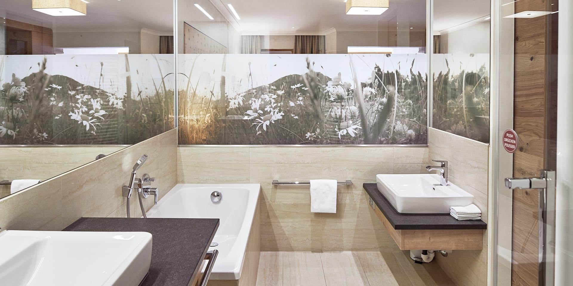 Modernes Badezimmer im Familienresort Buchau mit Badewanne und Waschtisch