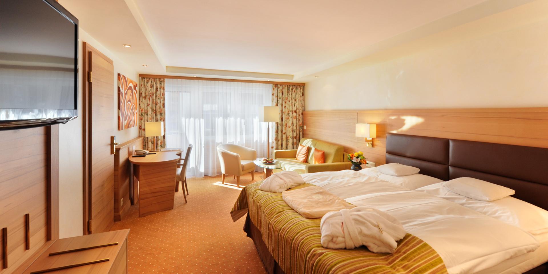 Gemütliches Zimmer im Resort La Ginabelle Zermatt mit Doppelbett und Sitzbereich