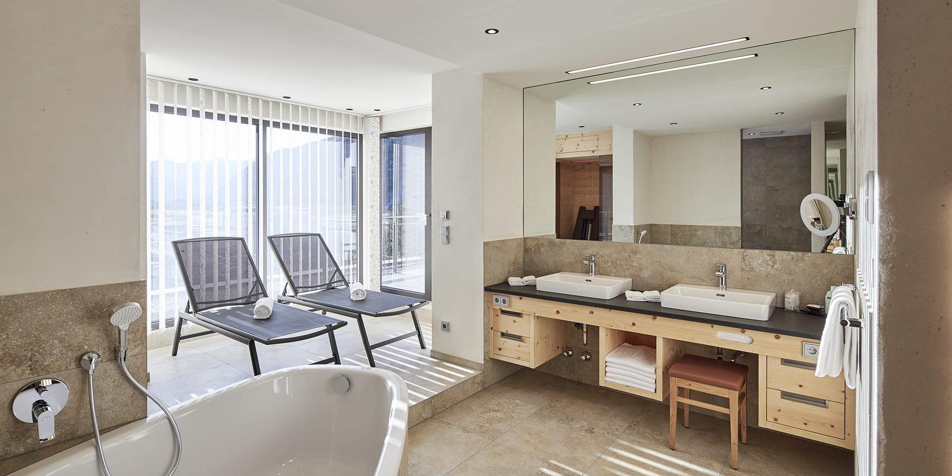 Modernes Badezimmer im Familienresort Buchau mit Wanne und Liegestühlen