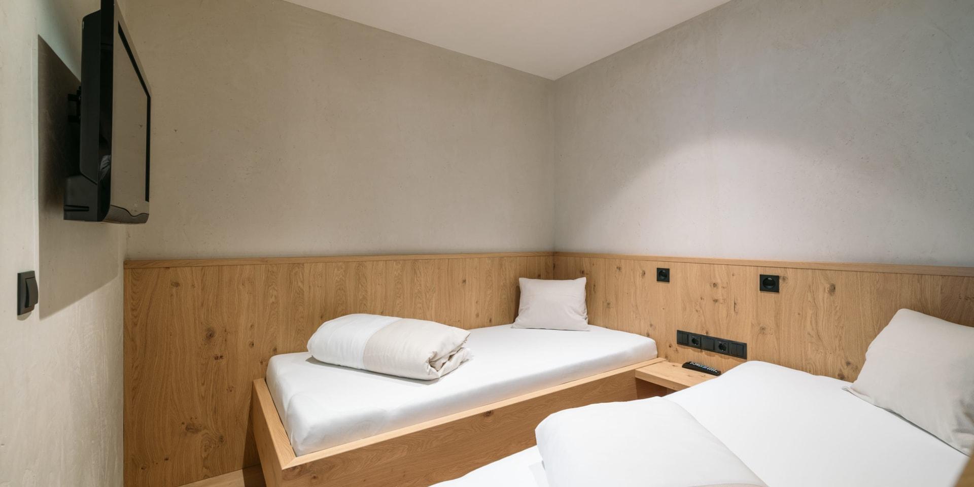 Schlichtes Schlafzimmer mit zwei Einzelbetten im Familienresort Buchau