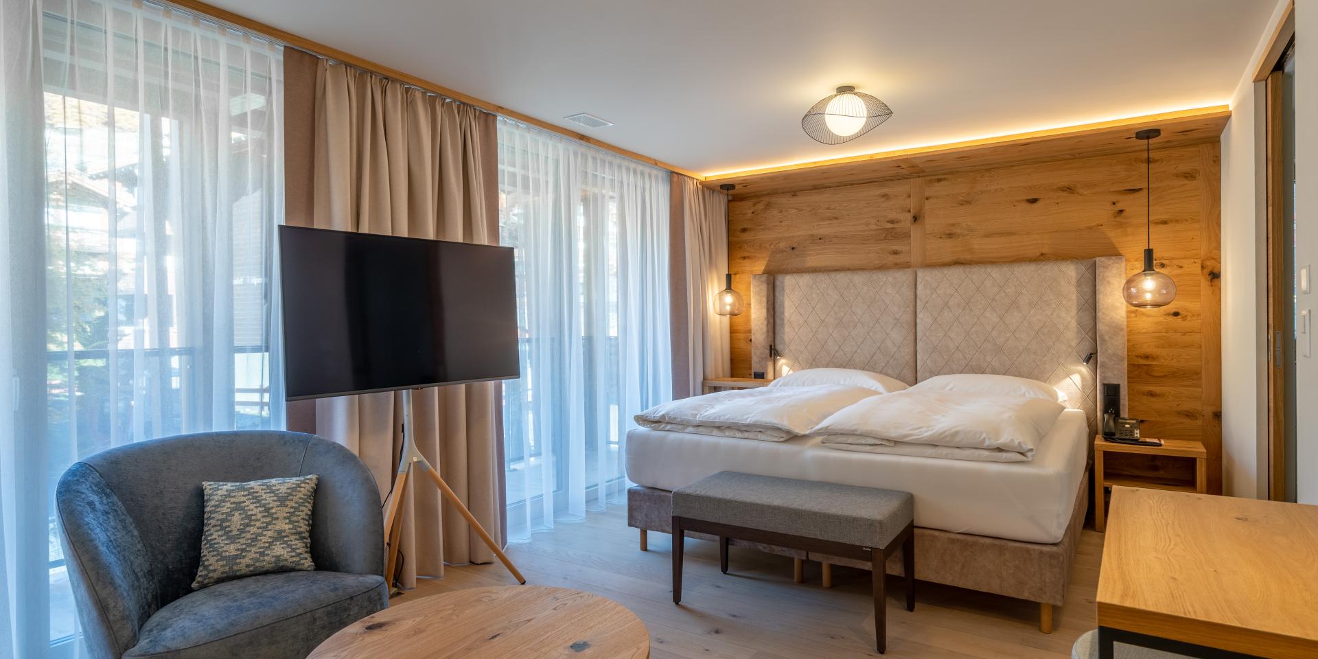 Chambre confortable au Resort La Ginabelle Zermatt avec décor en bois et balcon