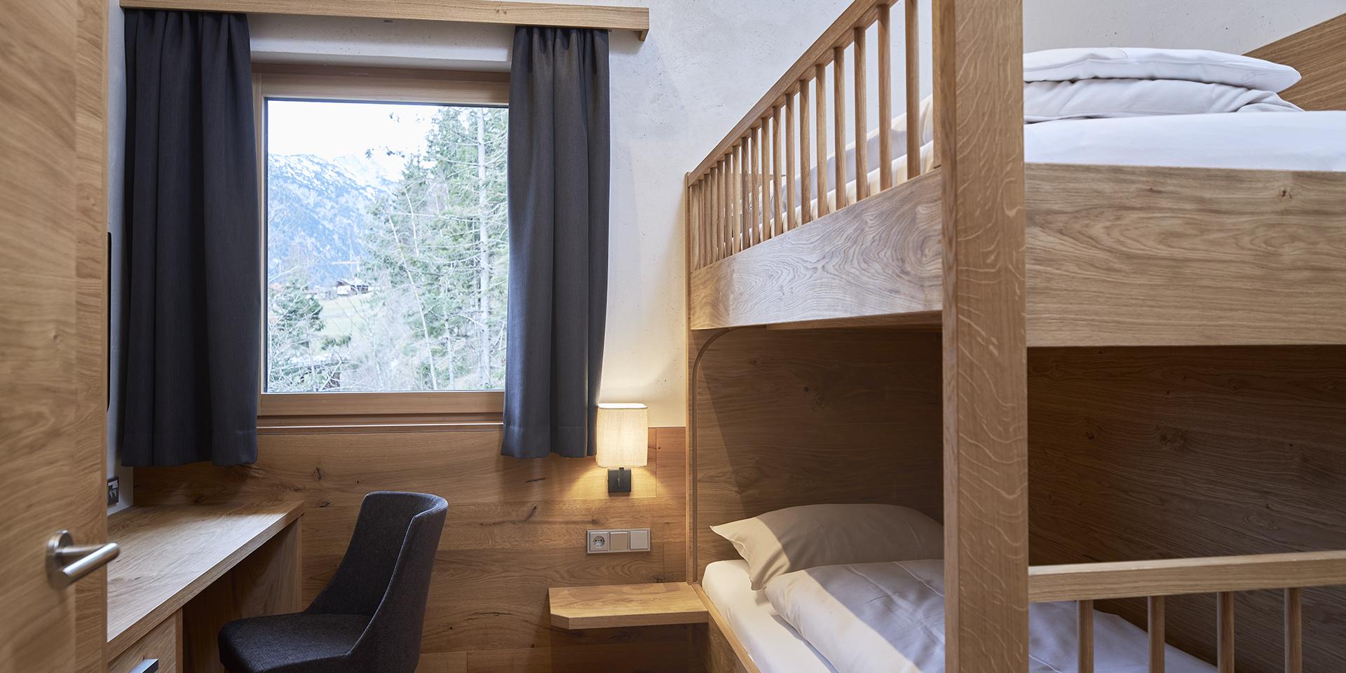 Schlafzimmer mit Etagenbett im Familienresort Buchau mit Bergblick