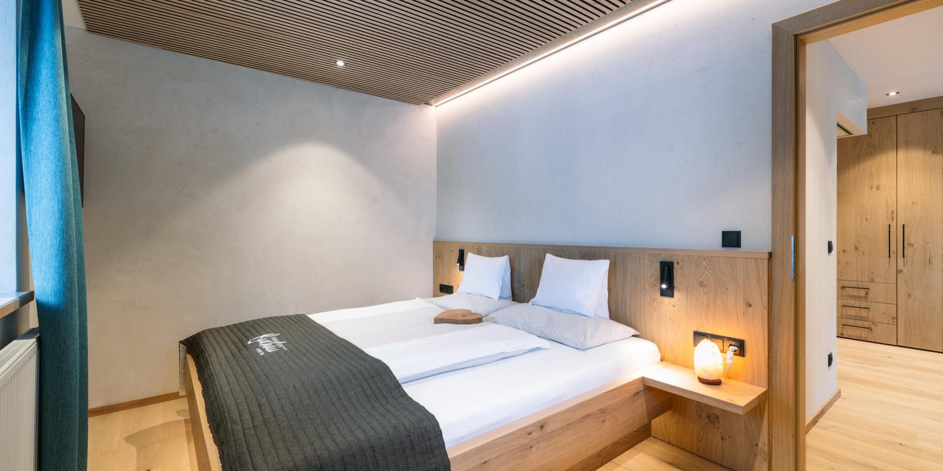 Gemütliches Schlafzimmer im Familienresort Buchau mit Doppelbett und Holzmöbeln