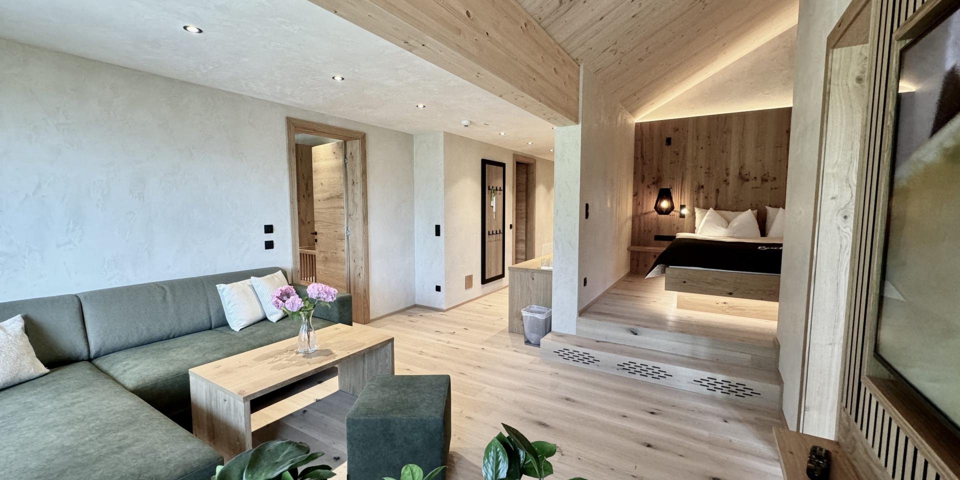 Moderne Suite im Familienresort Buchau mit Couch, Holzmöbeln und Schlafzimmer