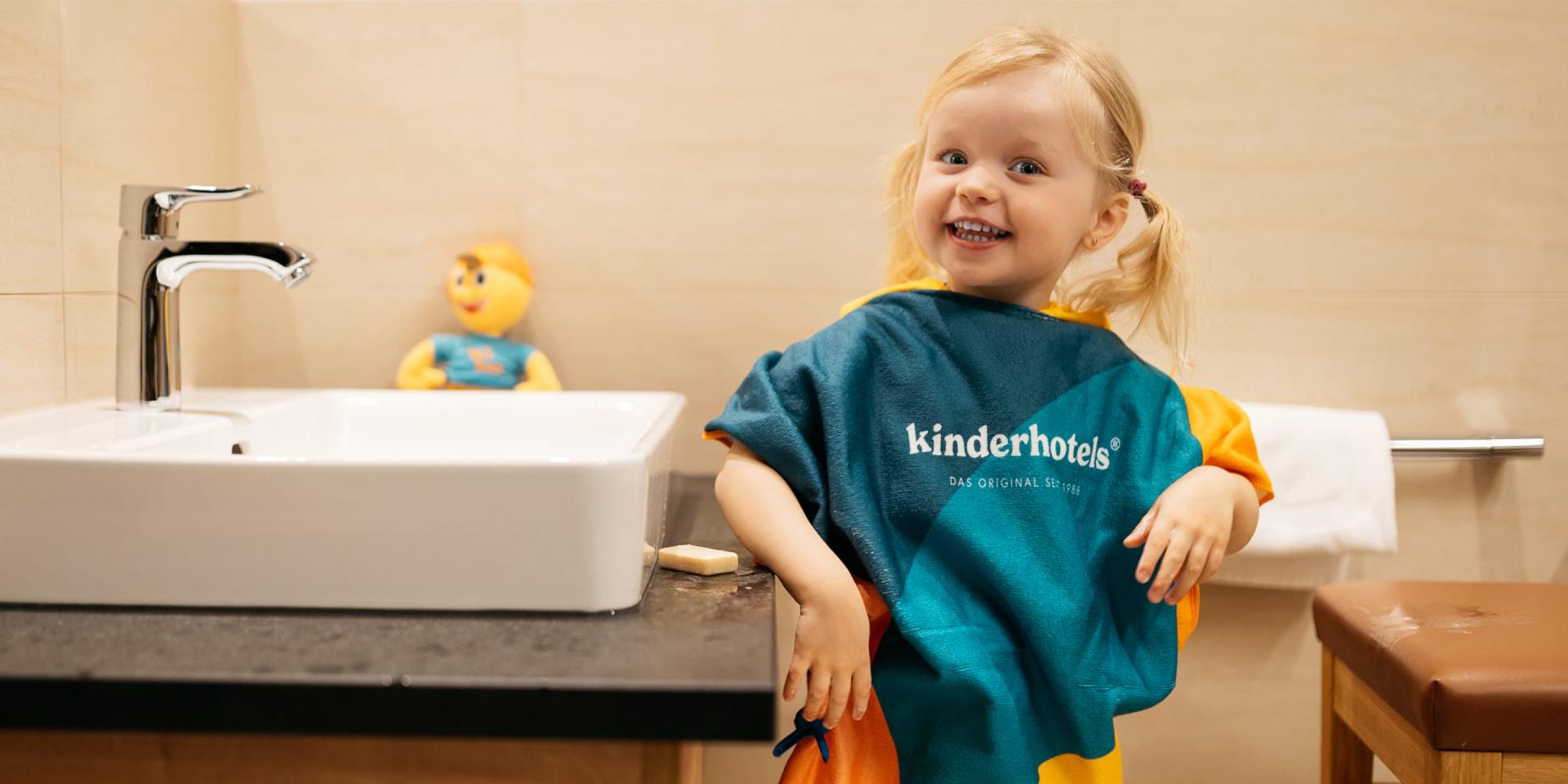 Fröhliches Kind im Badezimmer im Familienresort Buchau
