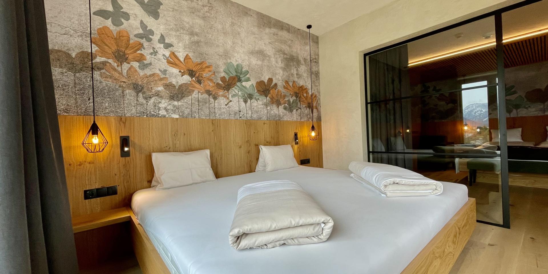 Modernes Schlafzimmer im Familienresort Buchau mit Doppelbett und Blumendekor