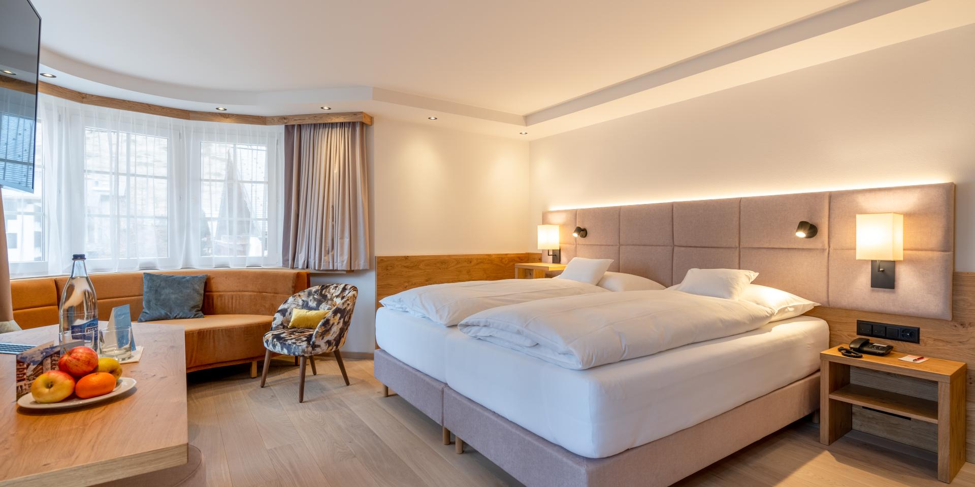 Modernes Zimmer im Resort La Ginabelle Zermatt mit gemütlichem Bett und Sitzbereich