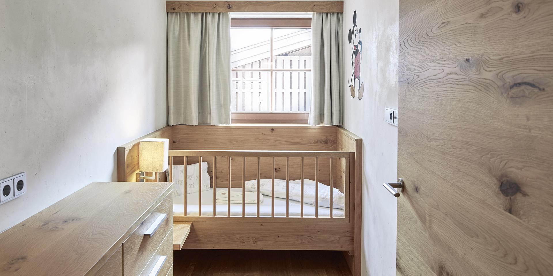 Kleines Kinderzimmer im Familienresort Buchau mit Holzmöbeln