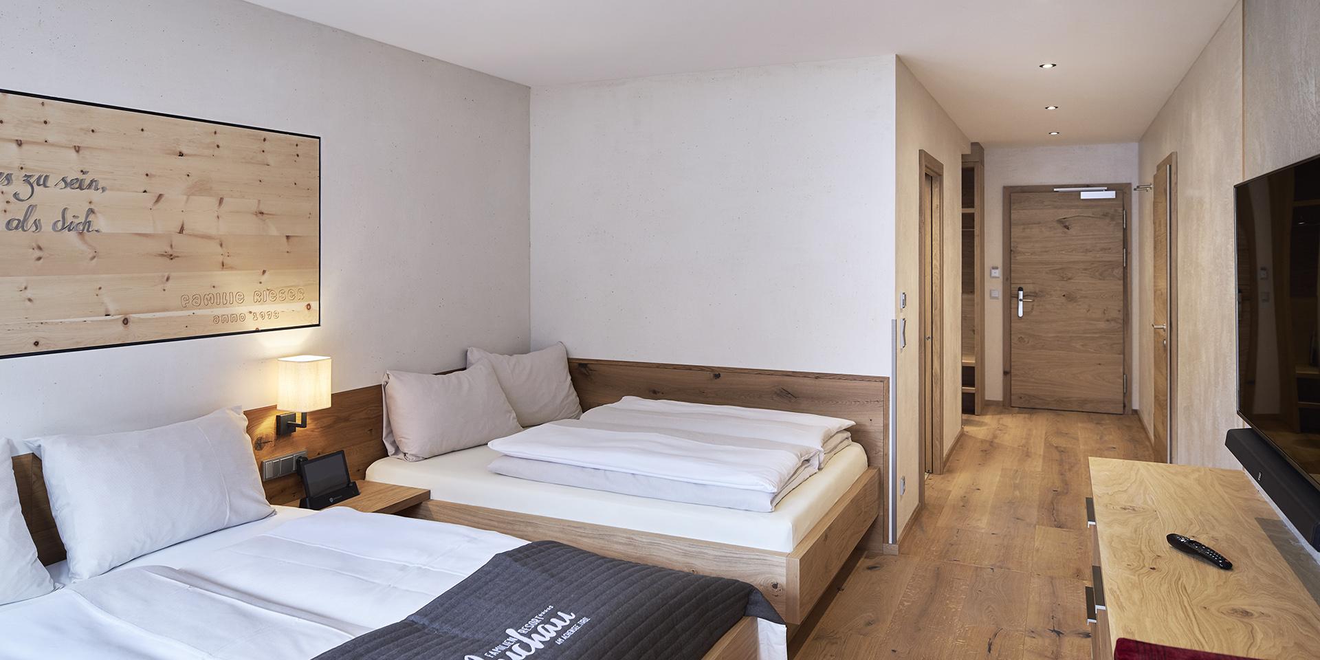 Modernes Familienzimmer im Familienresort Buchau mit zwei Betten und Holzfußboden