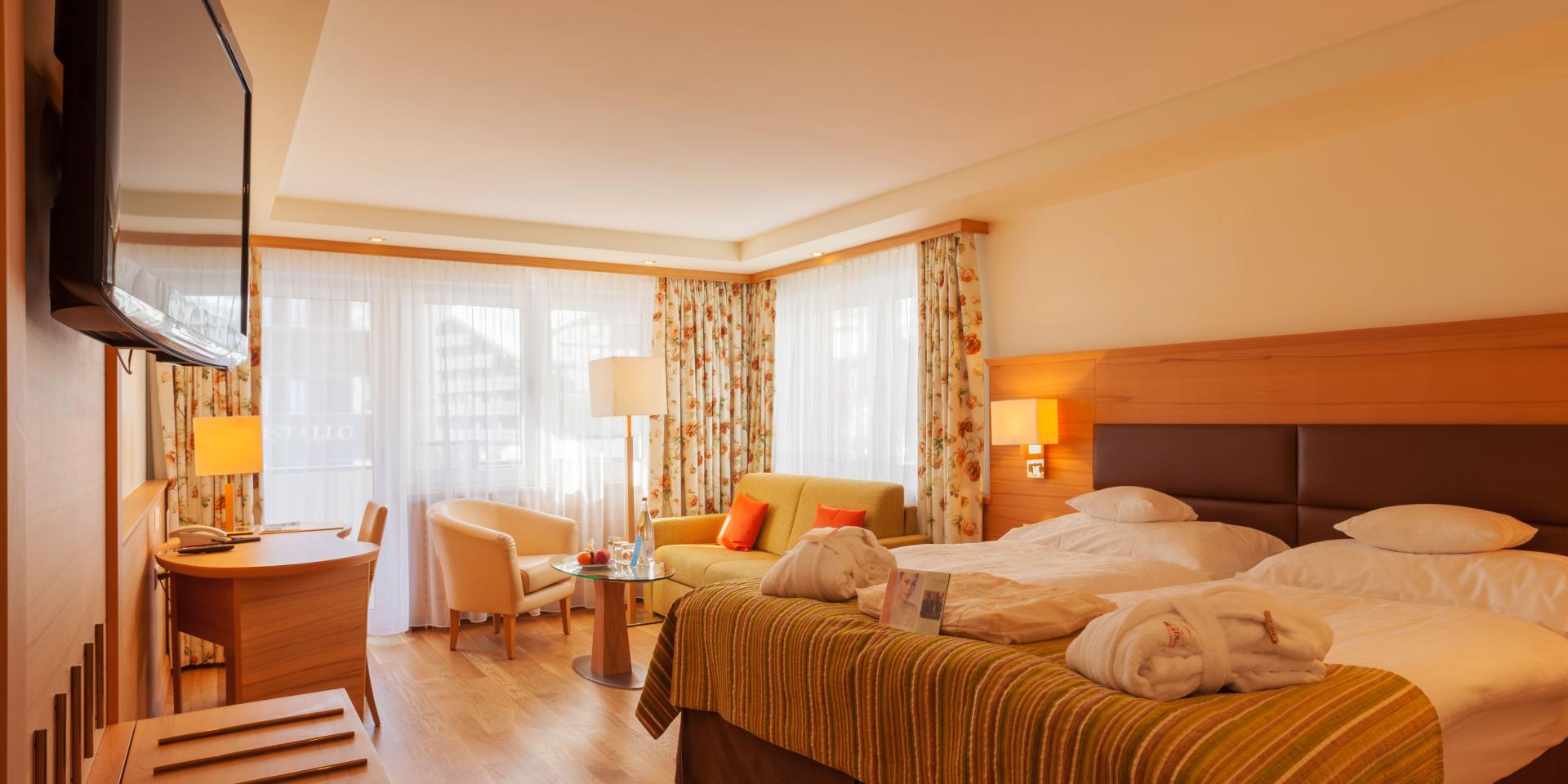 Gemütliches Doppelzimmer im Resort La Ginabelle Zermatt mit Sitzecke und TV