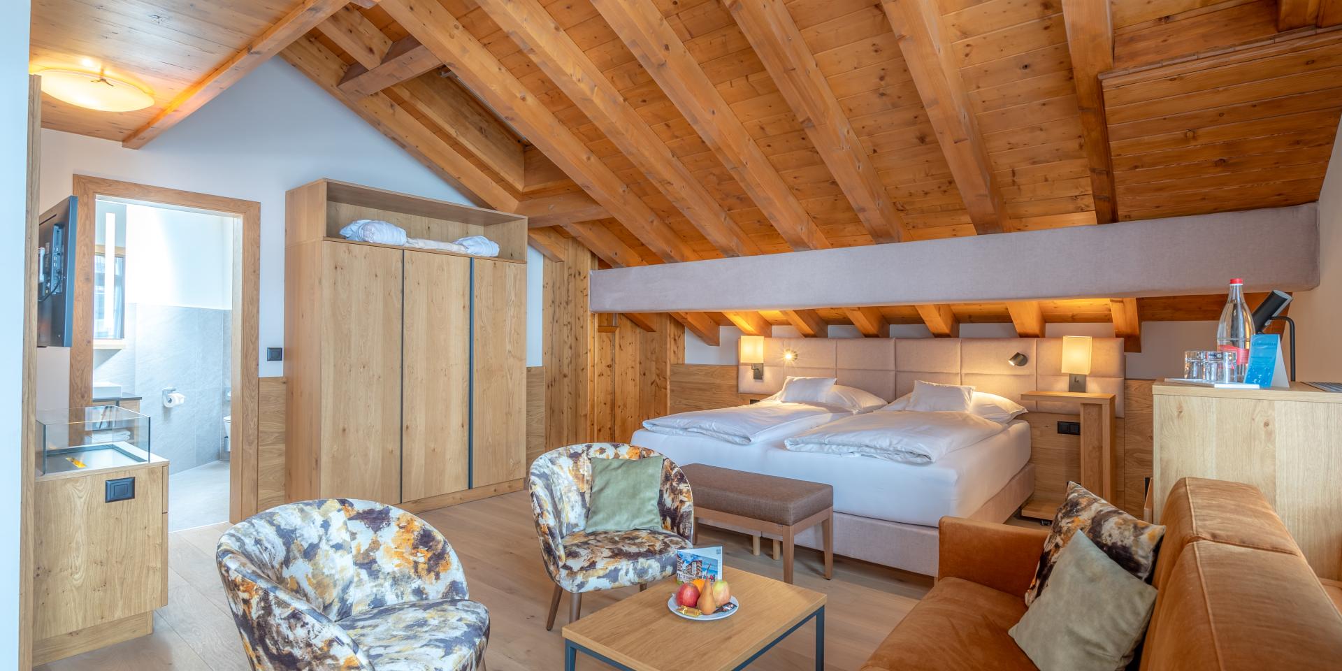 Gemütliches Zimmer im Resort La Ginabelle Zermatt mit Holzdecke und Sitzbereich