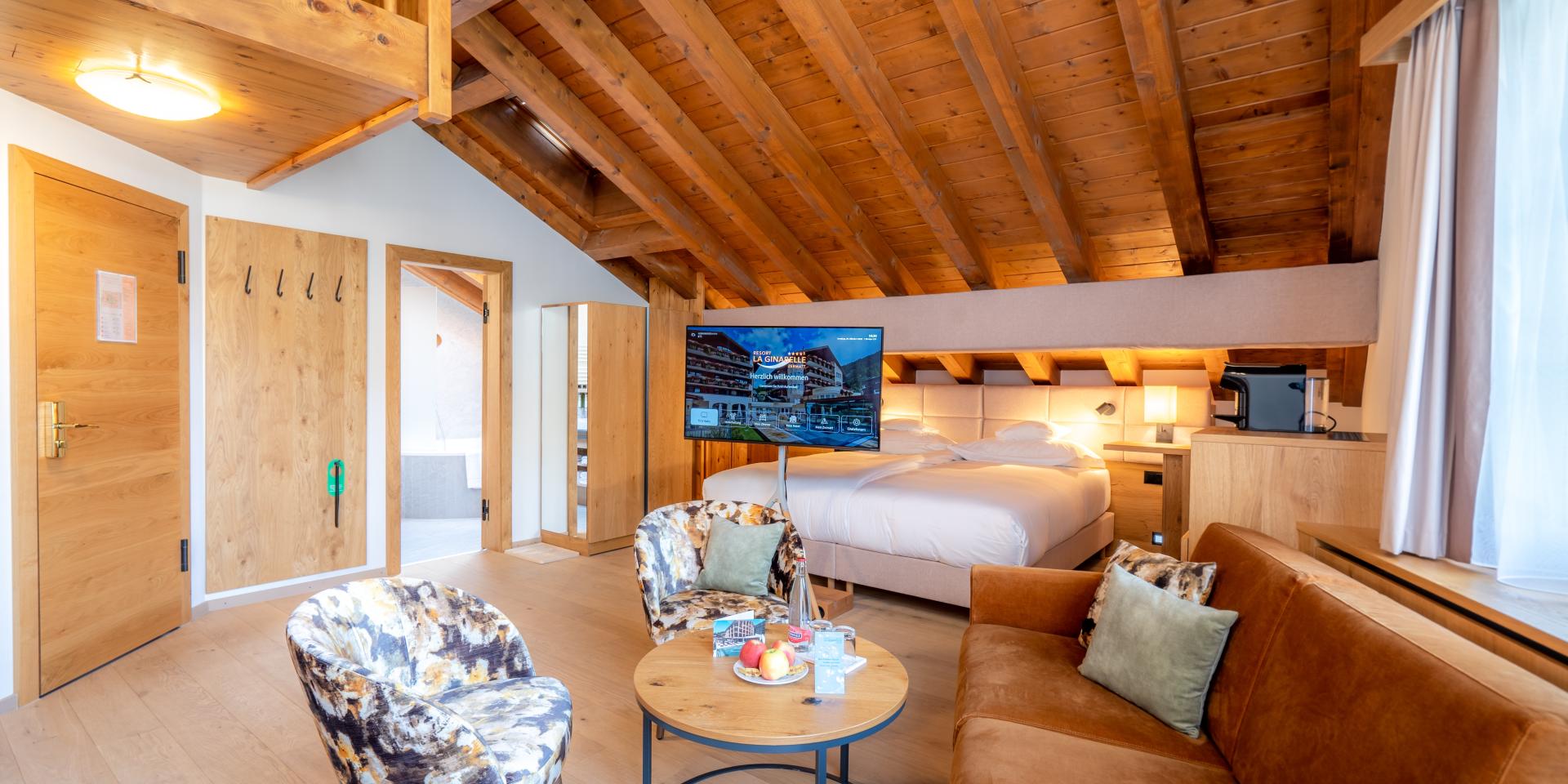 Gemütliches Zimmer im Resort La Ginabelle Zermatt mit Holzdecke und Sitzbereich