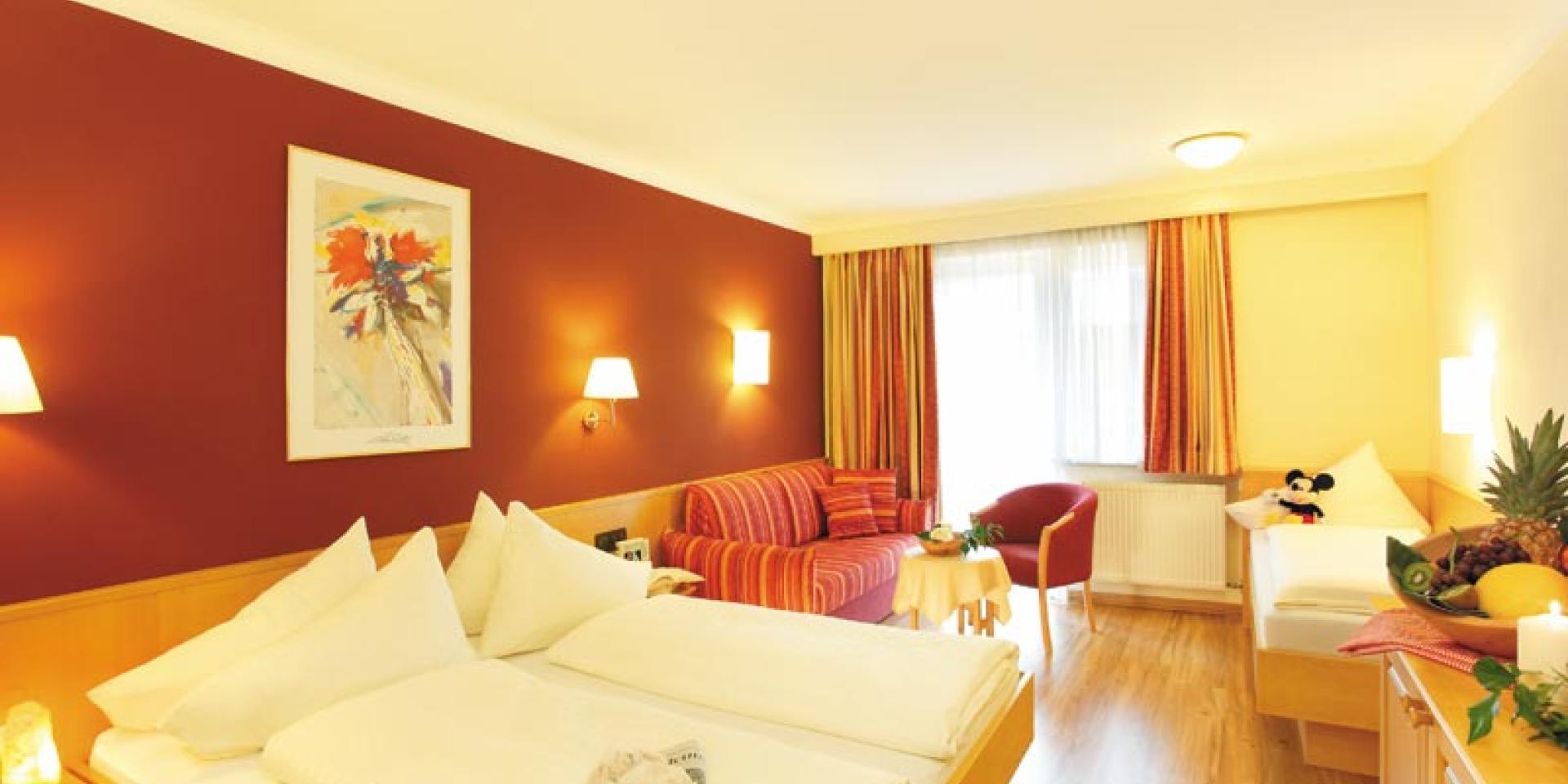 Gemütliches Familienzimmer im Familienresort Buchau mit Doppel- und Einzelbett.