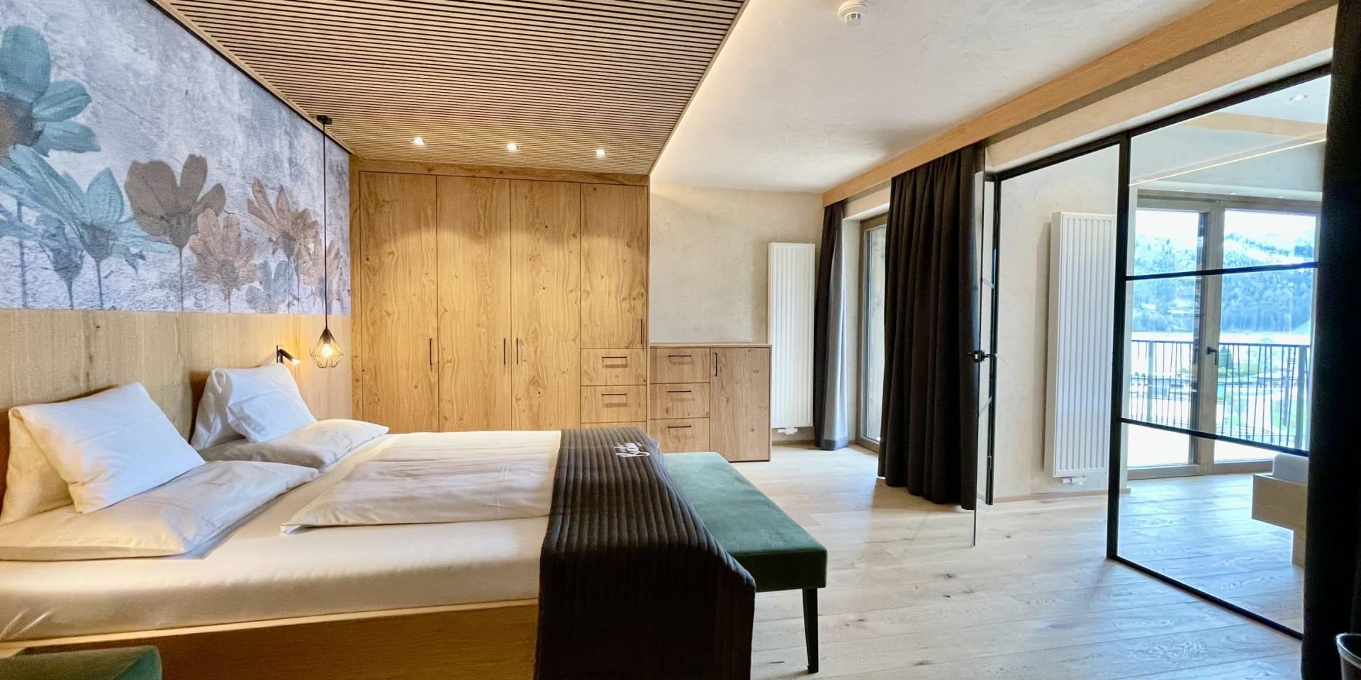 Modernes Schlafzimmer im Familienresort Buchau mit großem Bett und Balkon