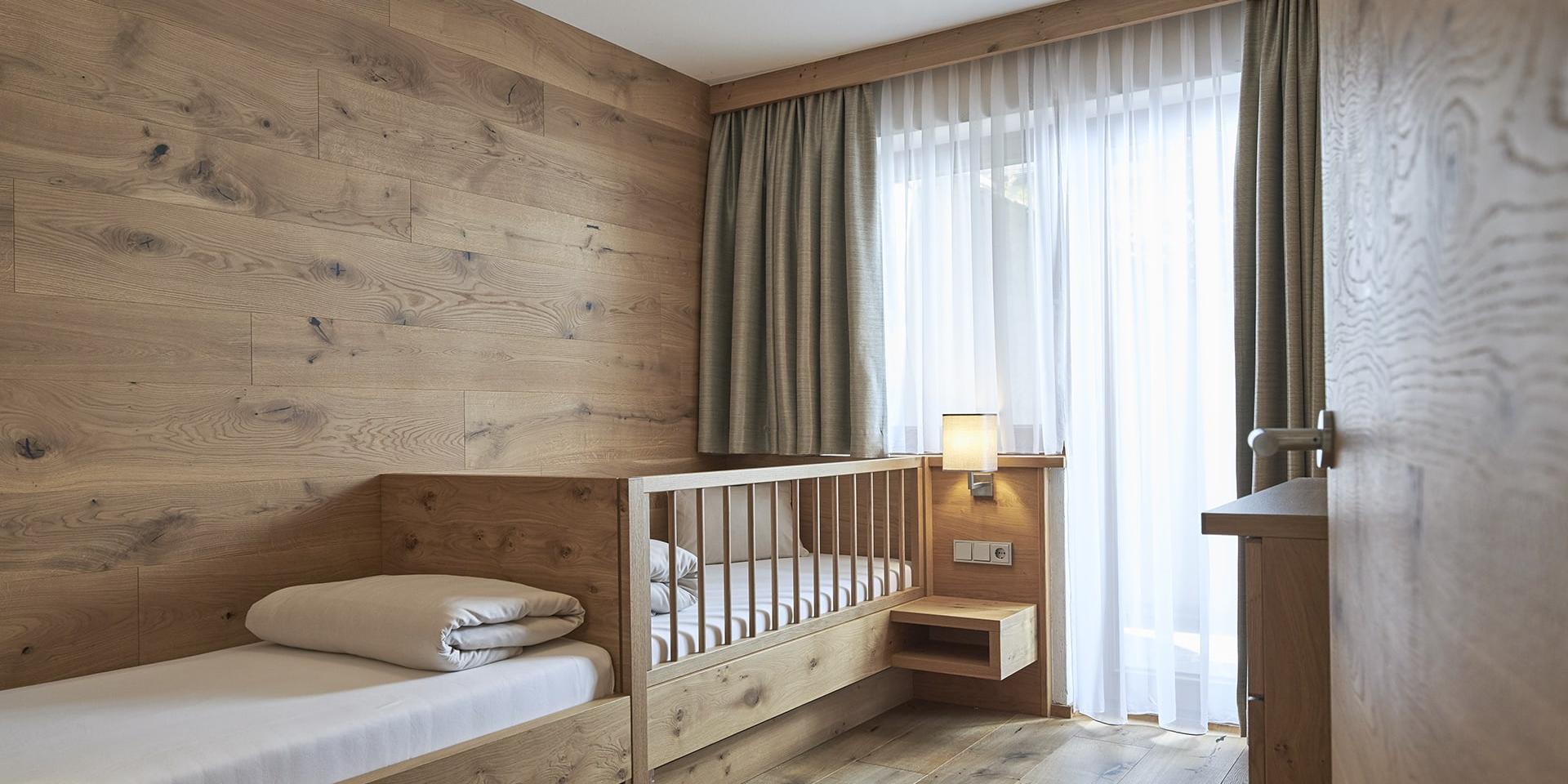 Kinderzimmer im Familienresort Buchau mit Holzmöbeln und Kinderbett