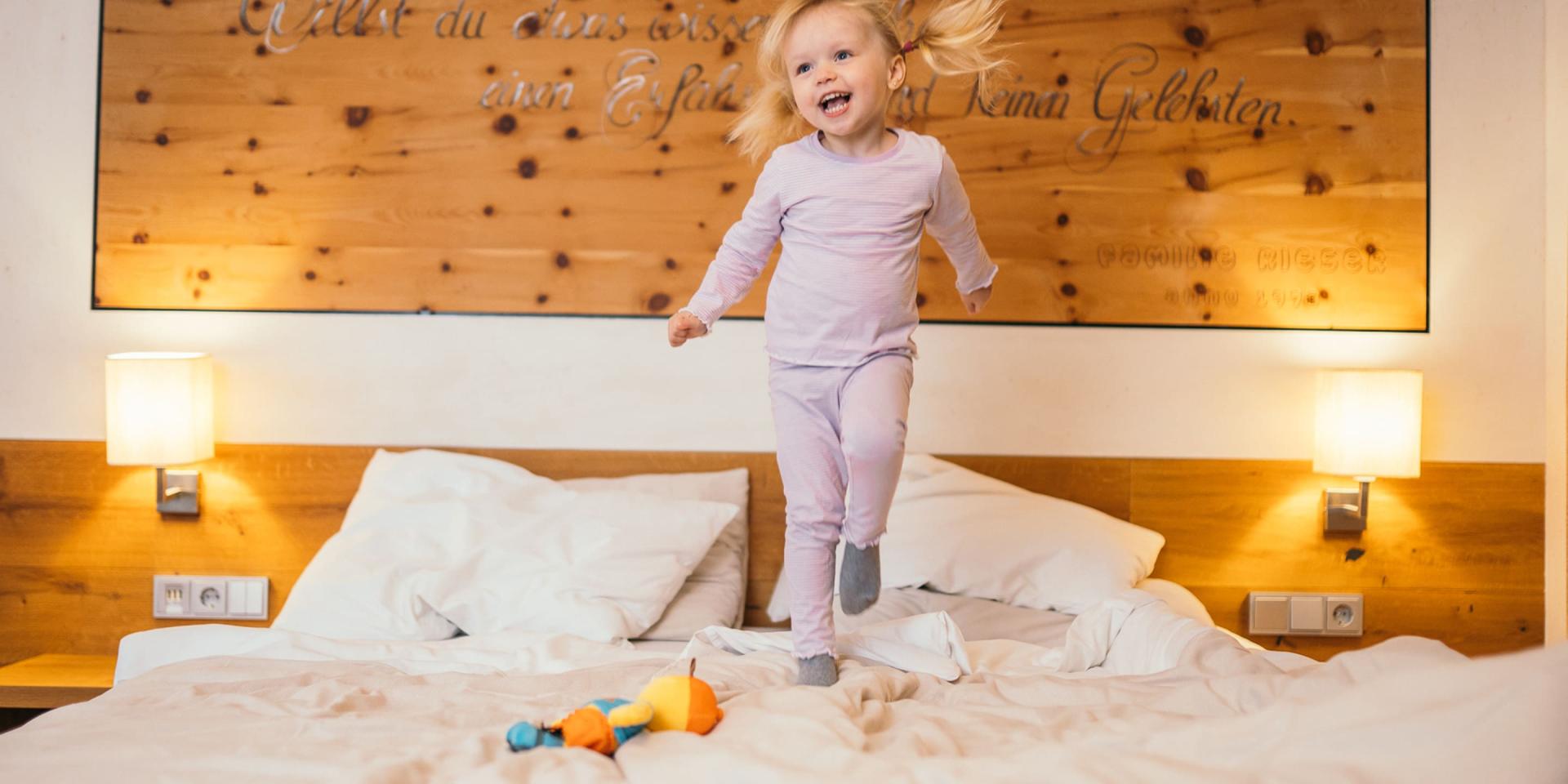 Kind springt auf einem Bett im Familienresort Buchau