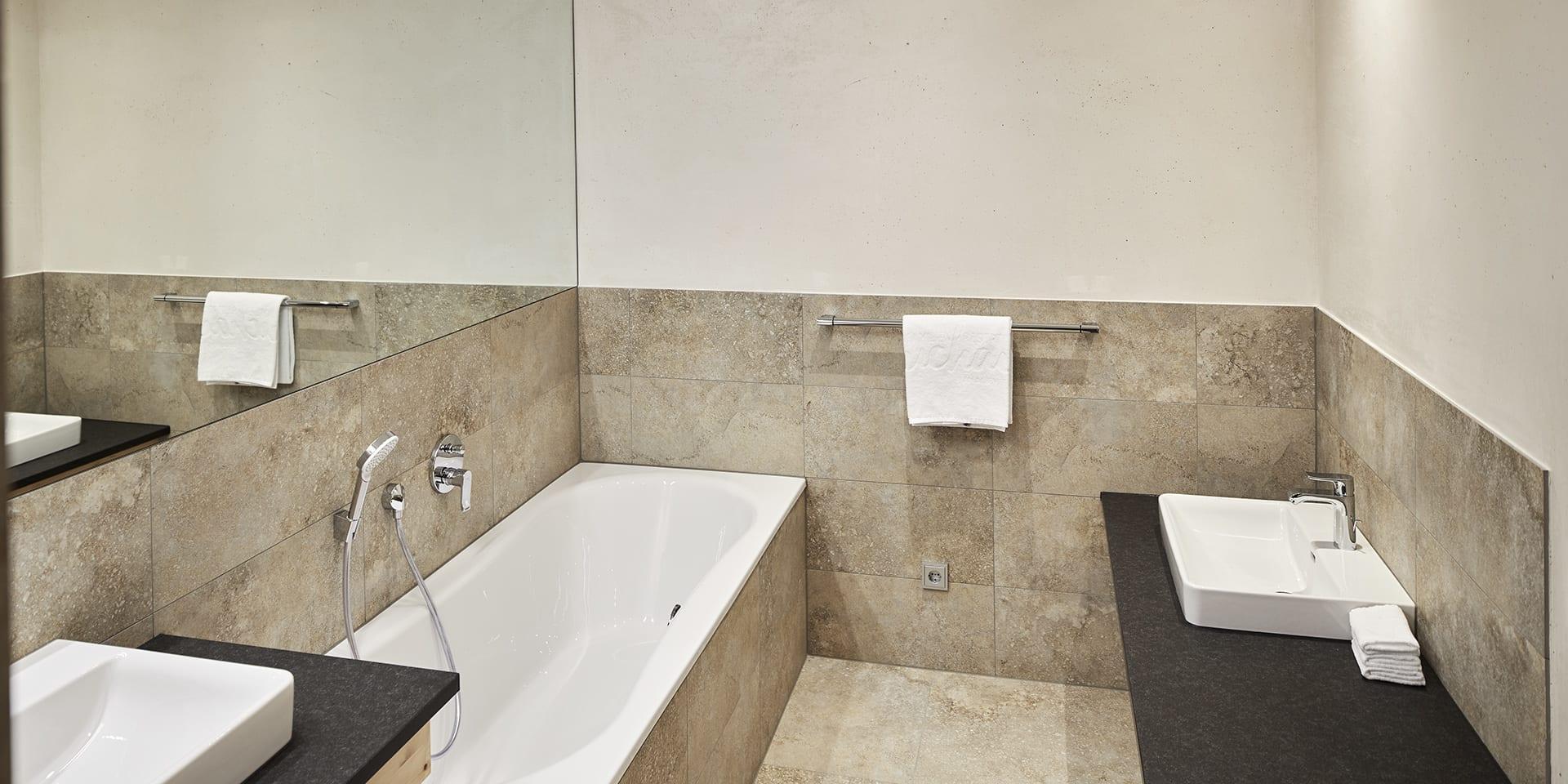 Modernes Badezimmer im Familienresort Buchau mit Badewanne und Waschbecken.