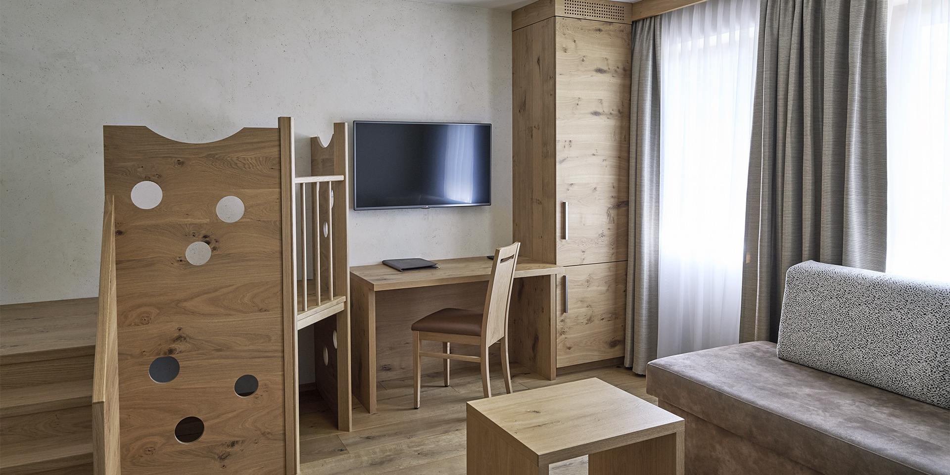 Modernes Familienzimmer im Familienresort Buchau mit Holzmöbeln und Spielbereich